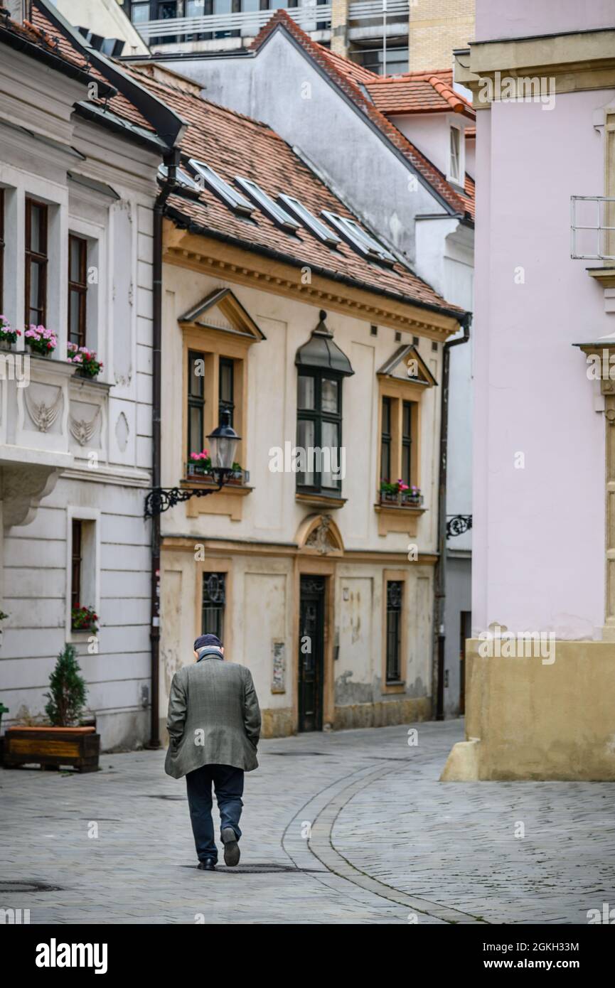 Ein alter Mann, der in der Straße des Stadtzentrums von Bratislava, Slowakei, läuft. Stockfoto