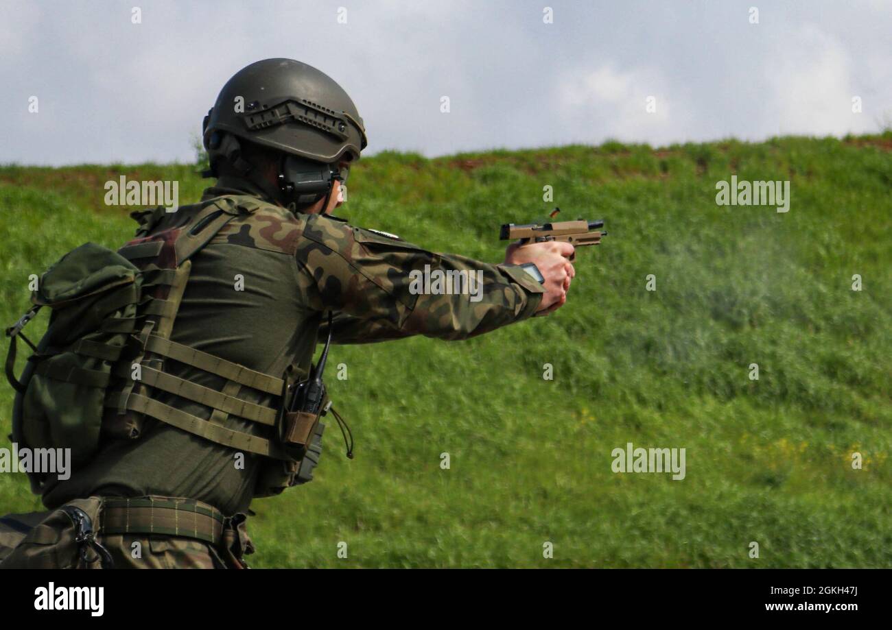 Ein Soldat der polnischen Streitkräfte feuert am 20. April 2021 eine Sig-Sauer-M17-Pistole auf ein Ziel während des Waffenqualifizierungswettbewerbs des Regionalkommandos Ost, des Kosovo Force Best Warrior Competition im Camp Bondsteel, Kosovo. US- und internationale Soldaten feuerten aus drei verschiedenen Positionen auf Ziele, um Punkte für das Ereignis zu sammeln. Stockfoto