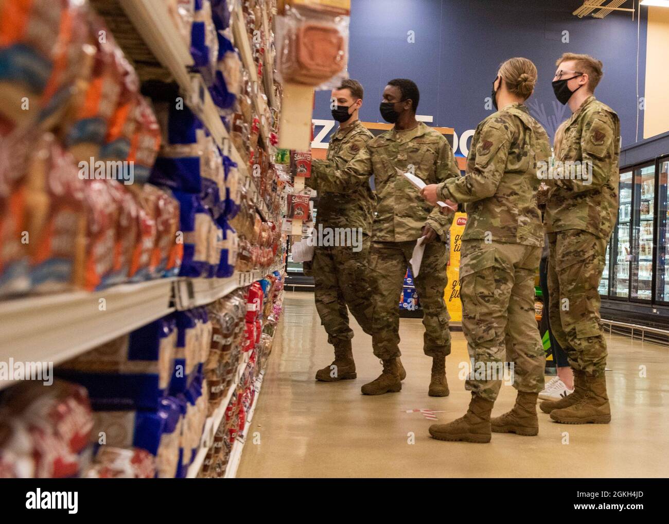US-Luftwaffe und Soldaten schauen sich während einer von der Gesundheitsförderung geleiteten Kommissarstour auf der Joint Base Elmendorf-Richardson, Alaska, am 19. April 2021, die Nährstoffetiketten auf verschiedenen Brotsorten an. Die Gesundheitsförderung strebt die Förderung von Gesundheit und Wohlbefinden für alle Militärmitglieder, ihre Angehörigen und Zivilpersonen des Verteidigungsministeriums durch Gemeinschafts- und Gruppenveranstaltungen an, um die Gesundheit, Einsatzbereitschaft und Produktivität der Militärgemeinschaft zu verbessern. Stockfoto