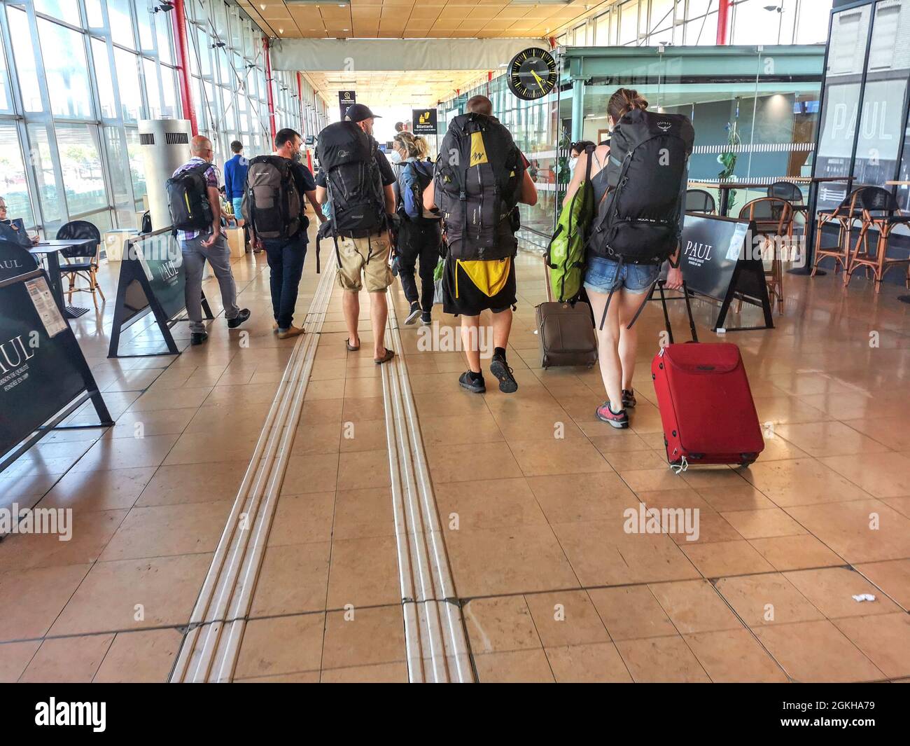Frankreich, Valence, 2021-07-01. Eine Gruppe junger Reisender mit Rucksack und Koffer geht in der Halle des TGV-Bahnhofs Valence spazieren. Phot Stockfoto