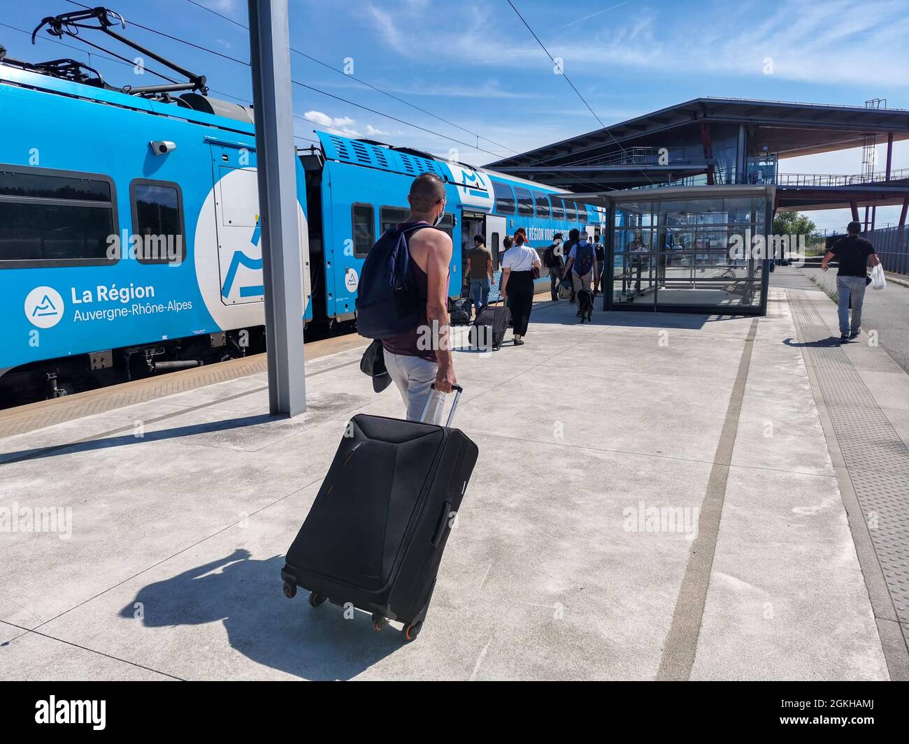 Frankreich, Valence, 2021-07-01. Ein Mann zieht einen Koffer auf dem  Bahnsteig des TGV-Bahnhofs Valence vor einem TER der Region Auvergne Rhone  Alpes. P Stockfotografie - Alamy