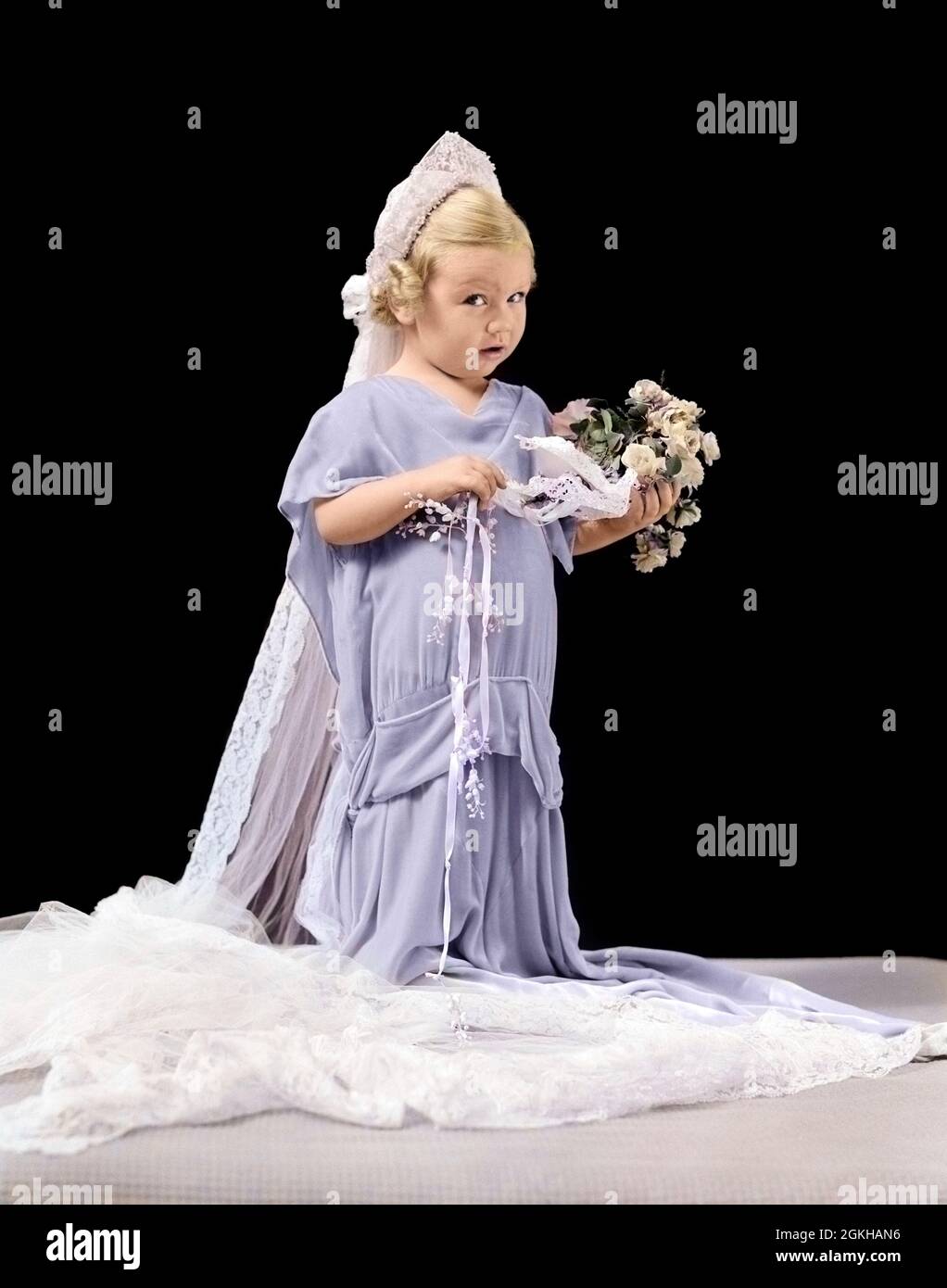 1940ER KLEINE BLONDE MÄDCHEN IN ÜBERDIMENSIONALEN HOCHZEITSKLEID & SCHLEIER HALTEN BOUQUET MIT VERWIRRTEN AUSDRUCK BLICK AUF DIE KAMERA - J2866C HAR001 HARS 1 BOUQUET JUVENILE CUTE STYLE BLONDE LIFESTYLE FEIER FRAUEN ERWACHSENE KOPIEREN RAUM MENSCHEN KINDER VOLLER LÄNGE SCHLEIER ZEREMONIE ÜBERGROSS AUGENKONTAKT DURCHGANG BRÄUTE STRÄUSSE VON UNSICHER DRESS-UP PHANTASIE RITUS DER PASSAGE SCHÜCHTERN STILVOLLE BLUME MÄDCHEN COY BLUME MÄDCHEN JUGENDLICHE ROLLEN SPIELEN SKEPTISCHE KAUKASISCHE ETHNIE HAR001 ALTMODISCH Stockfoto