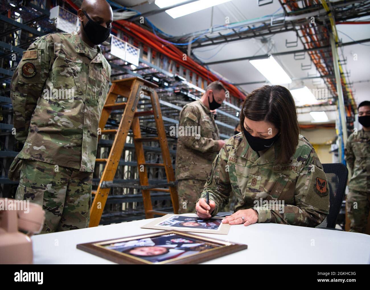 Chief Master Sgt. Der Air Force Joanne S. Bass signiert Fotos für das 2. Kommunikationsgeschwader während ihres Besuchs auf der Barksdale Air Force Base, Louisiana, 22. April 2021. Bass verbrachte ihre Zeit bei Barksdale, um Airmen zu besuchen und sich mit ihrer Rolle vertraut zu machen, die sie dabei spielte, der Nation globale Bomberfähigkeiten zu bieten. Stockfoto