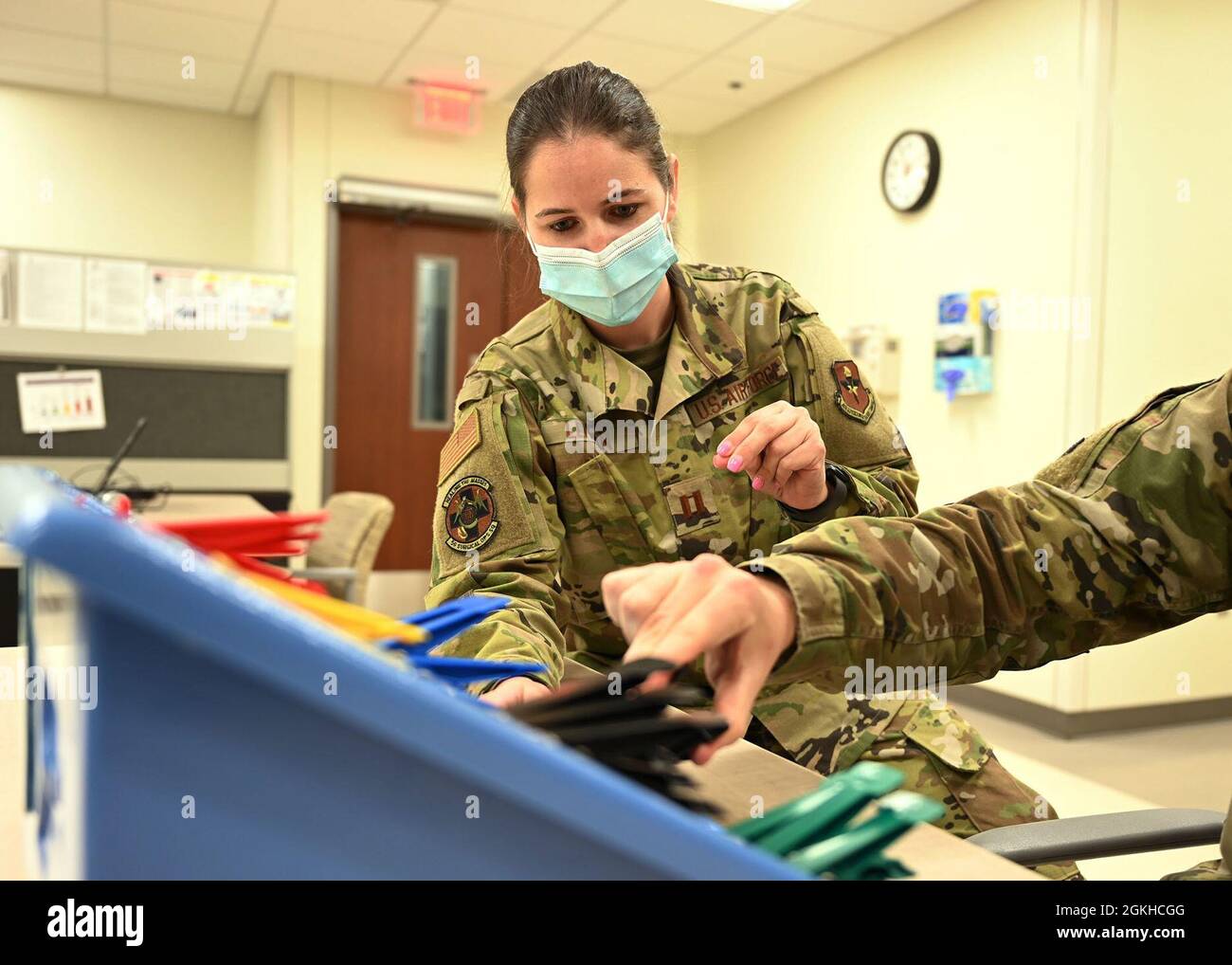 Capt. Karena Lehman, Leiterin der Beschäftigungstherapie des 59. Medizinischen Flügels, führt einen Patienten durch das Fingerkraft- und Geschicklichkeitstraining im Wilford Hall Ambulatory Surgical Center, Joint Base San Antonio-Lackland, Texas, 22. April 2021. Ergotherapeuten nutzen einen ganzheitlichen Ansatz mit evidenzbasierter Praxis, um das Umfeld oder die Aufgabe eines Patienten an seine Bedürfnisse anzupassen. Stockfoto