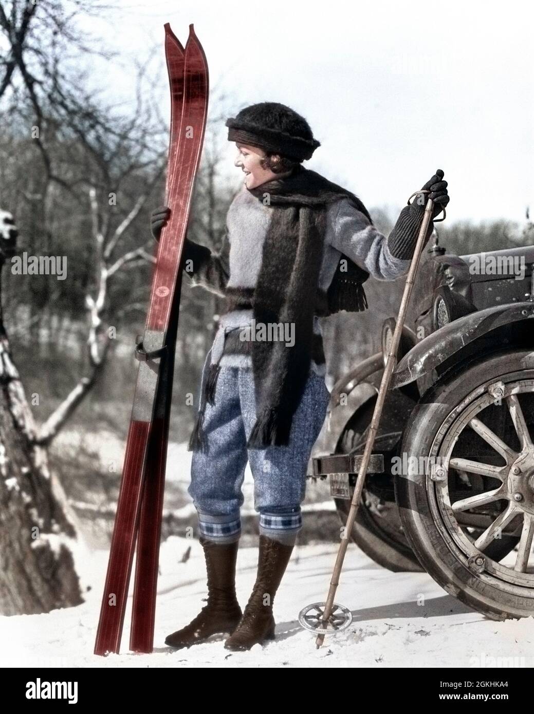 FRAU AUS DEN 1920ER JAHREN IM SCHAL HUT UND STIEFEL STEHEN VOR DEM AUTO MIT HOLZSKIERN UND BAMBUSSKISTÖCKEN - W82C HAR001 HARS JUNGE ERWACHSENE LIFESTYLE FRAUEN VERTIKAL LÄNDLICHEN ERWACHSENEN WOLLE VOLLE LÄNGE AUTOMOBILRÄDER VERTRAUEN BOOT WINTERZEIT VERÖFFENTLICHT WINTERSAISON AKTIVITÄT BAMBUS ABENTEUER HOBBY FREIZEIT AUTOS AUFREGUNG HOBBYS ERHOLUNG AUTOMOBIL AUTOFAHREN JAHRESZEITEN AUTOS STYLISH AUTOFAHRER ERHOLUNG WINTER ENTSPANNUNG SAISON WANDERN JUNGE ERWACHSENE FRAU KAUKASISCHE ETHNIE HAR001 ALTMODISCH Stockfoto