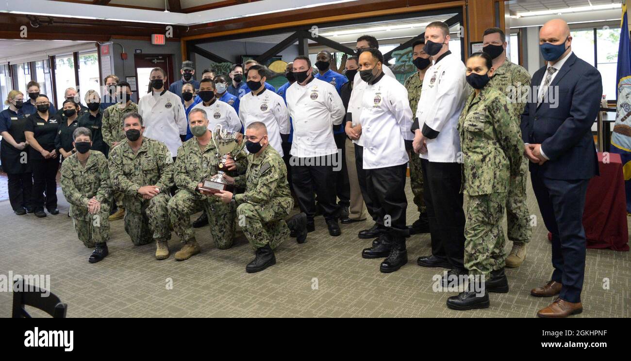 SILVERDALE, Wash. (26. April 2021) ADM hinten. Peter Stamatopoulos, Kommandant des Naval Supply Systems Command, posiert für ein Foto mit Kapitän Richard Rhinehart, Kommandeur des Marinestützpunktes Kitsap, und Mitarbeitern des Trident Galley Inn der NBK an Bord von NBK-Bangor. Die Galeere gewann den Captain Edward F. Ney Memorial Award 2021 für exzellente Gastronomie in der Kategorie „West Coast General Mess“. Stockfoto