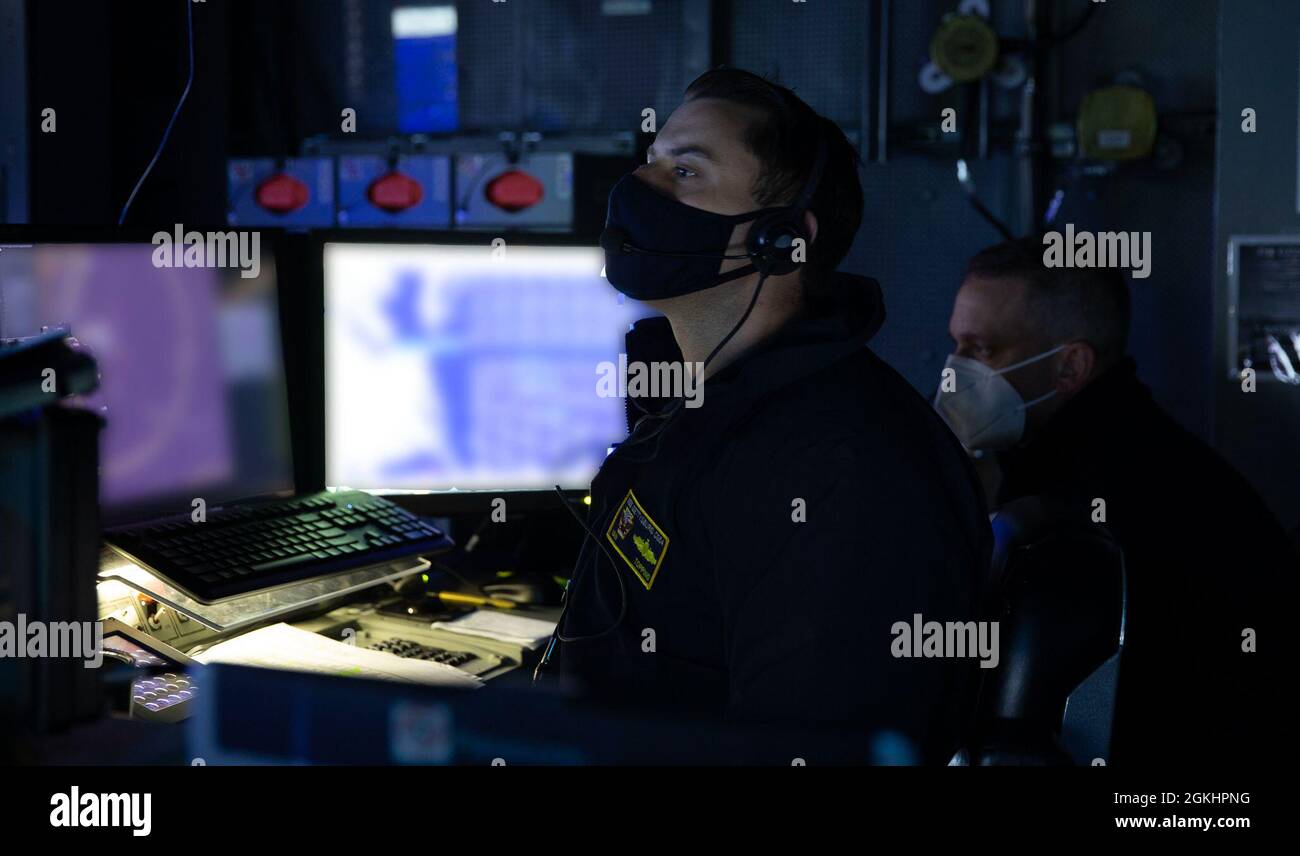 Lt. Bef. Ian Topping, links, USS Gettysburgs (CG 64) Operations Security Officer, und LT. Cmdr. Aaron Young, Gettysburgs Perspective Operations Officer, beobachtet an Bord der USS Gerald R. Ford (CVN 78) im Tactical Flag Command Center eine Luftverteidigungsübung von einer Luft- und Raketenabwehrkoordinationskonsole aus, 26. April 2021. Unter der Führung von CSG-12 führt Gerald R. Ford im Atlantik integrierte Streikgruppen-Operationen mit CVW-8, DESRON 2 und ihrem Kommandanten der Luft- und Raketenabwehr, Kommandant der USS Gettysburg (CG 64), durch. (Dieses Bild war alte Stockfoto