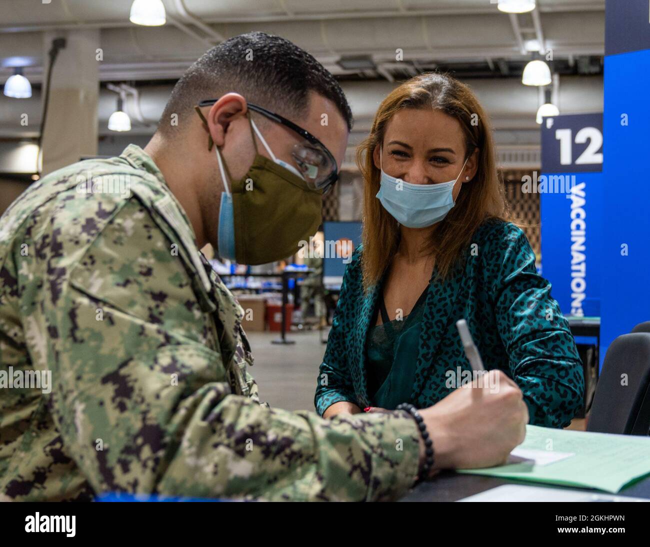 Christopher Rivas, ein gebürtiger Bostoner, der dem Naval Medical Center Portsmouth, Virginia, zugewiesen wurde, nimmt die Informationen seiner Mutter, Sheila Chourouk Mansora, über einen COVID-19-Impfstoff an das Community Vaccine Center im Hynes Convention Center in Boston, 26. April 2021. Rivas’ nutzte die Gelegenheit, seine Mutter während der 4. Woche der Marine, die nach Boston eingesetzt wurde, zu impfen. Seeleute der US-Marine aus dem ganzen Land werden zur Unterstützung der Impfeinsätze des Verteidigungsministeriums eingesetzt. Das U.S. Northern Command, über die U.S. Army North, ist weiterhin der Vorsorge verpflichtet Stockfoto