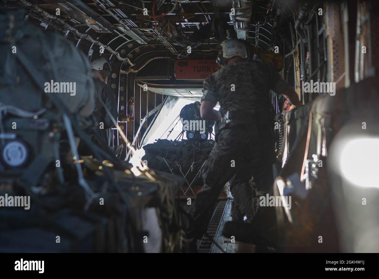 US Marine Corps Staff Sgt. Marvin Loverkamp schiebt ein Joint Precision AirDrop System (JPADS) aus einem CH-53 Super Hengst in der Landing Zone Falcon, Marine Corps Base Camp Lejeune, North Carolina, 27. April 2021. Marine Heavy Helicopter Squadron 461 (HMH-461) nutzte den JPADS, um schnelle und präzise, hochgelegene Artilleriesimunition für die Übung Rolling Thunder an die Marineinfanteristen des 10. Marine Regiments zu liefern. Die JPADS nutzt GPS, eine modulare autonome Führungseinheit, einen Fallschirm und Elektromotoren, um die Ladung mit großer Präzision entlang eines vorbestimmten Gleitens und in ihre Zielbereiche zu leiten Stockfoto