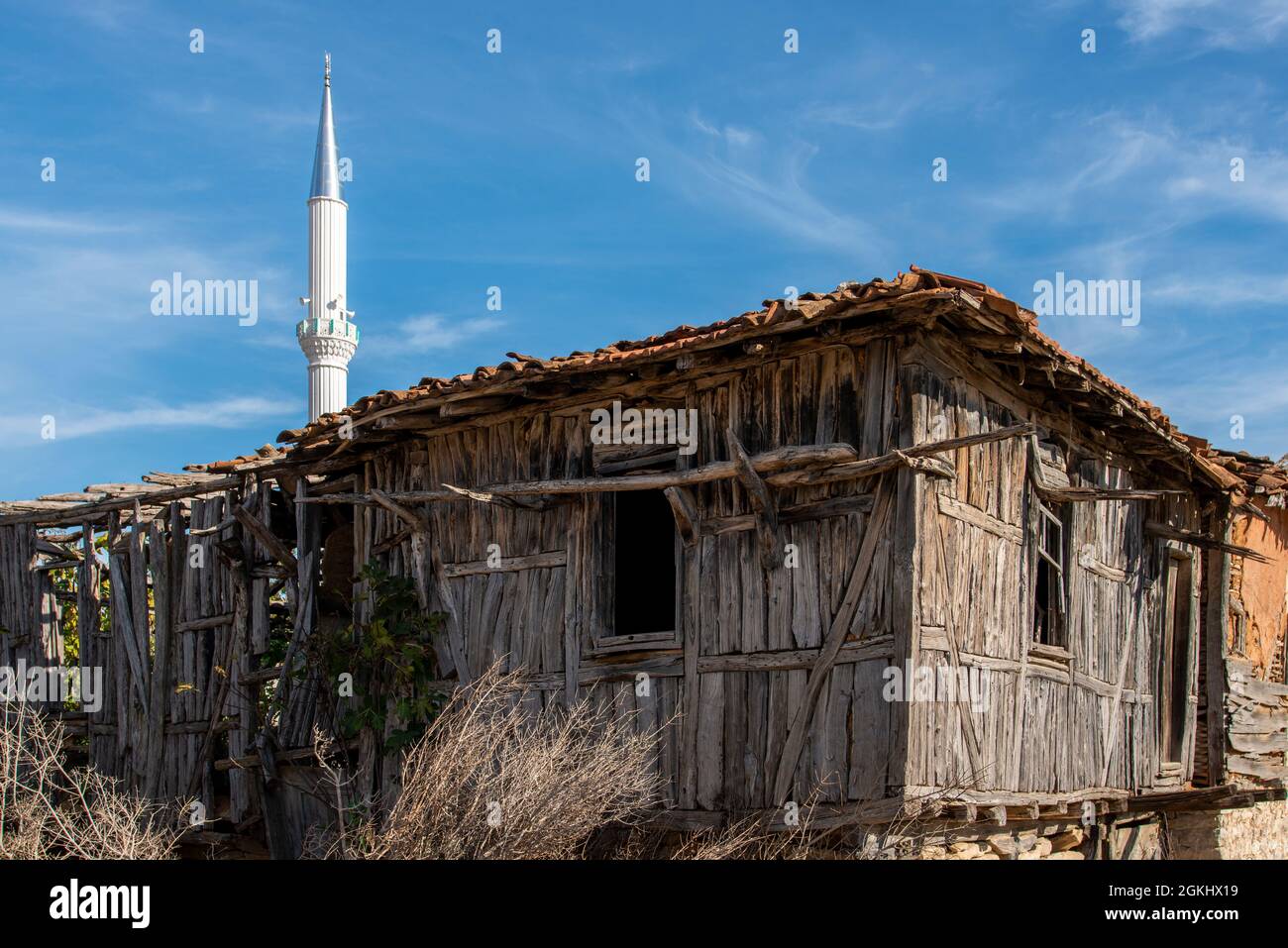 Vintage unbehandelten Holzschuppen und Moschee Minarett hinter irgendwo in der türkei Stockfoto