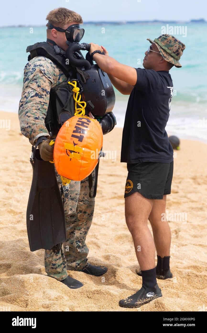 U.S. Marine Corps CPL. Edin Berns und Capt. Spencer Buettner mit Force Reconnaissance Platoon (FRP), 31. Marine Expeditionary Unit (MEU), überprüfen Sie die Ausrüstung vor einem Unterwassernavigationskurs in Kin Blue, Okinawa, Japan, 27. April 2021. FRP führte Tauchwiederholungen durch, um die Leistungsfähigkeit und Währung als Kombattentaucher zu erhalten. Die 31. MEU, die einzige kontinuierlich im Vorlauf eingesetzte MEU des Marine Corps, stellt eine flexible und tödliche Truppe bereit, die als führende Krisenreaktionstruppe in der Indo-Pazifik-Region eine breite Palette von Militäroperationen durchführen kann. Stockfoto