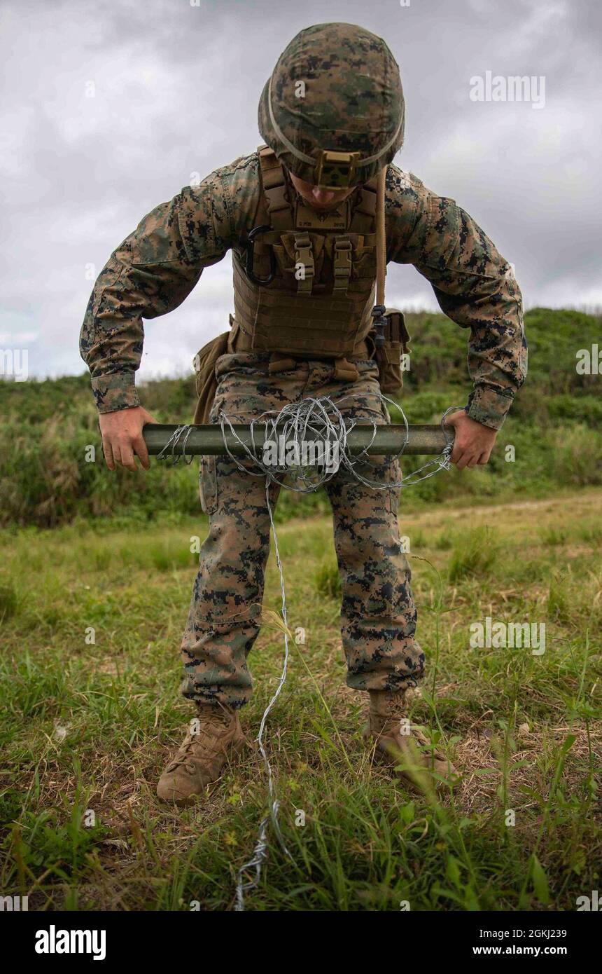 U.S. Marine Corps Lance CPL. Gianluca Forte, ein Kampfingenieur, der am 3d-Bataillon, 3d Marines, befestigt ist, verstärkt eine defensive Position mit einem konzertanten Draht auf IE Shima, Okinawa, Japan, 27. April 2021. 3/3 verbesserte ihre Kompetenz in verteilten Betrieben und demonstrierte gleichzeitig ihre Fähigkeit, wichtiges maritimes Terrain in der Indo-Pazifik-Region schnell zu sichern und zu verteidigen. 3/3 wird im Rahmen des Unit Deployment Program im Indo-Pacific unter 4th Marines, 3d Marine Division, eingesetzt. Forte stammt aus Toronto, Kanada. Stockfoto