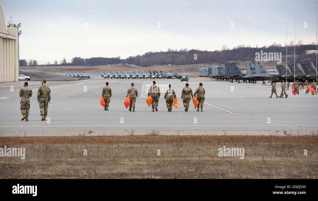 Die dem 3. Flügel zugewiesenen Flieger führen auf der Fluglinie auf der Joint Base Elmendorf-Richardson, Alaska, einen Fremdkörperablagerungen durch, der am 29. April 2021 durchgeführt wird. Die dem 3. Flügel zugewiesenen aktiven Militärflugzeuge, die Reserve-Flieger der 477. Kampfgruppe und die Alaska Air National Guardsmen des 176. Flügels führten den FOD-Spaziergang durch, um Trümmer zu entfernen, die möglicherweise Flugzeuge beschädigen und die Einsatzbereitschaft behindern könnten. Stockfoto