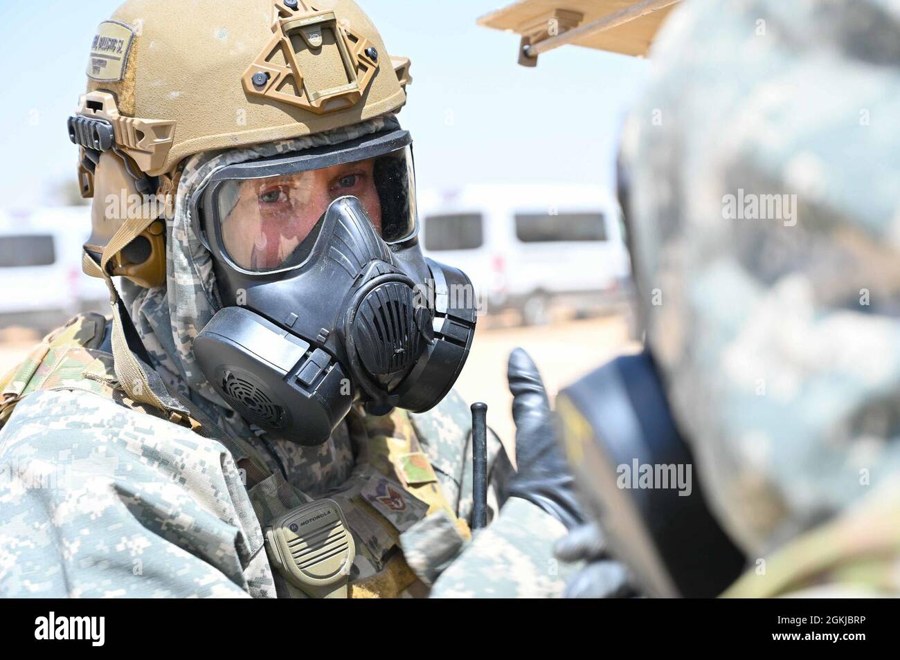 US Air Force Staff Sgt. Wayne Walker spricht mit einem EOD Airman während einer Übung im 332. Air Expeditionary Wing, wo sie auf eine simulierte, nicht explodierte Sprengkraft reagierten, 30. April 2021. Trotz der steigenden Temperaturen entschieden sich Walker und die anderen Airmen dafür, sich in „chem-Gear“ einzupassen, um eine tatsächliche Reaktion besser zu simulieren. Stockfoto