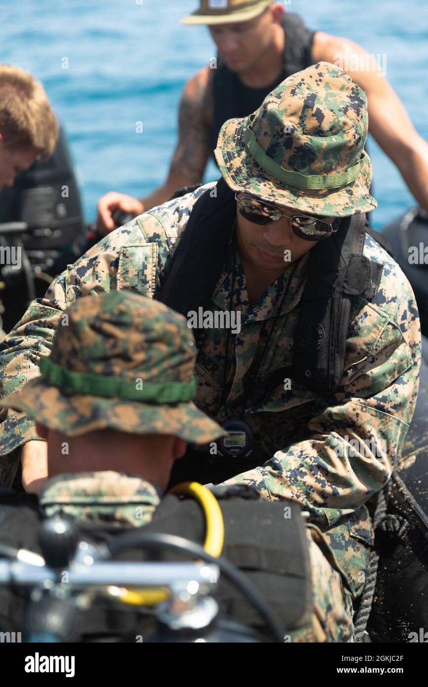 Der verantwortliche Offizier des U.S. Marine Corps, Spencer Buettner, mit dem Force Reconnaissance Platoon (FRP), der 31. Marine Expeditionary Unit (MEU), führt Sicherheitskontrollen an einem Taucher durch, bevor er am 30. April 2021 einen Tauchtiefkurs in Kin Blue, Okinawa, Japan, beginnt. FRP führte Tauchwiederholungen durch, um die Leistungsfähigkeit und Währung als Kombattentaucher zu erhalten. Die 31. MEU, die einzige kontinuierlich im Vorlauf eingesetzte MEU des Marine Corps, stellt eine flexible und tödliche Truppe bereit, die als führende Krisenreaktionstruppe in der Indo-Pazifik-Region eine breite Palette von Militäroperationen durchführen kann. Stockfoto