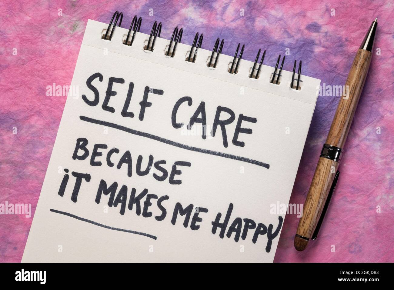 Selbstpflege, weil es mich glücklich macht - inspirierende Erinnerung, Handschrift auf einem Spiralnotizbuch, Lifestyle- und Gesundheitskonzept Stockfoto