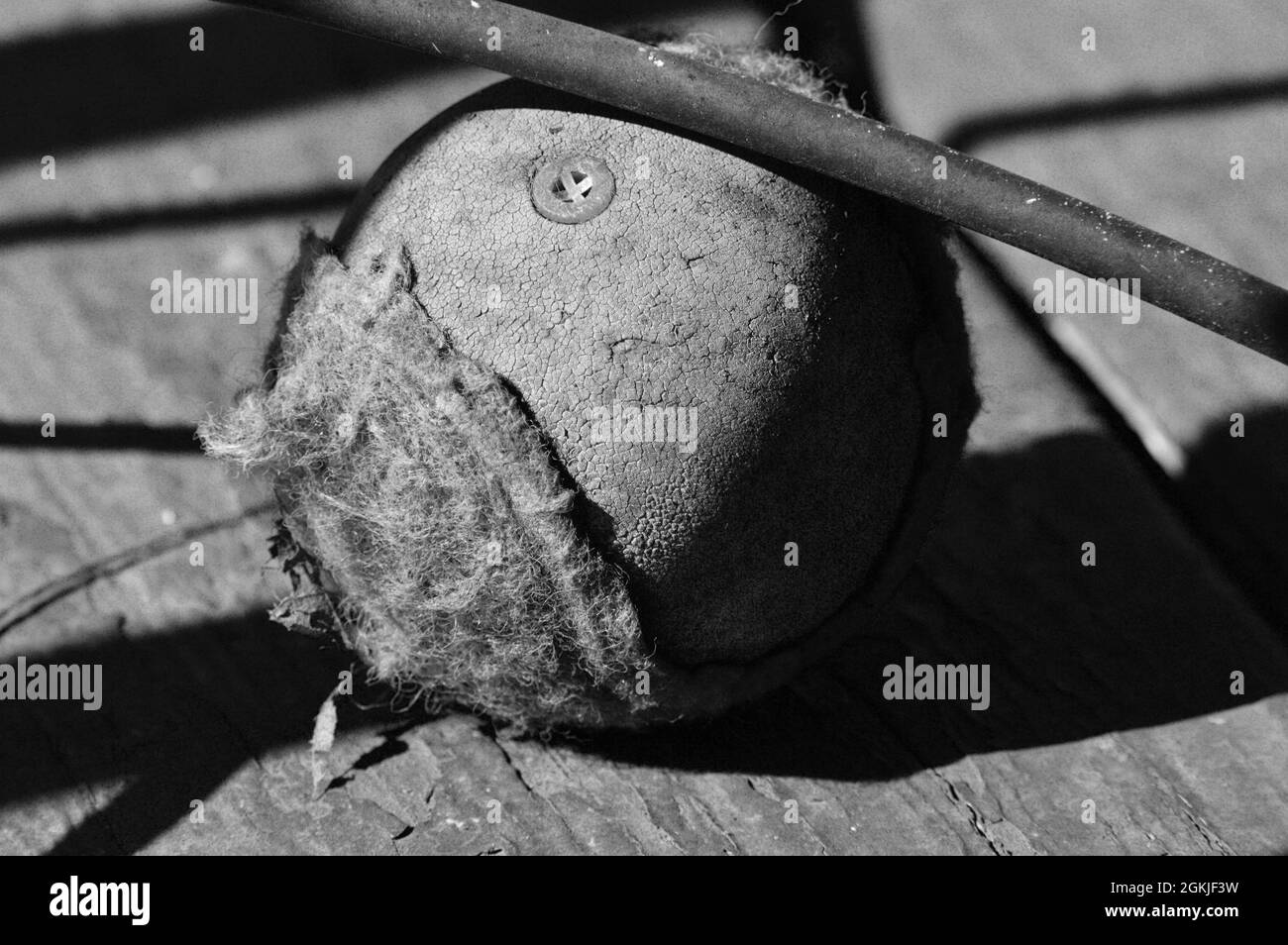 Ein schwarz-weiß eines Tennisballs unter einem Stuhl Stockfoto