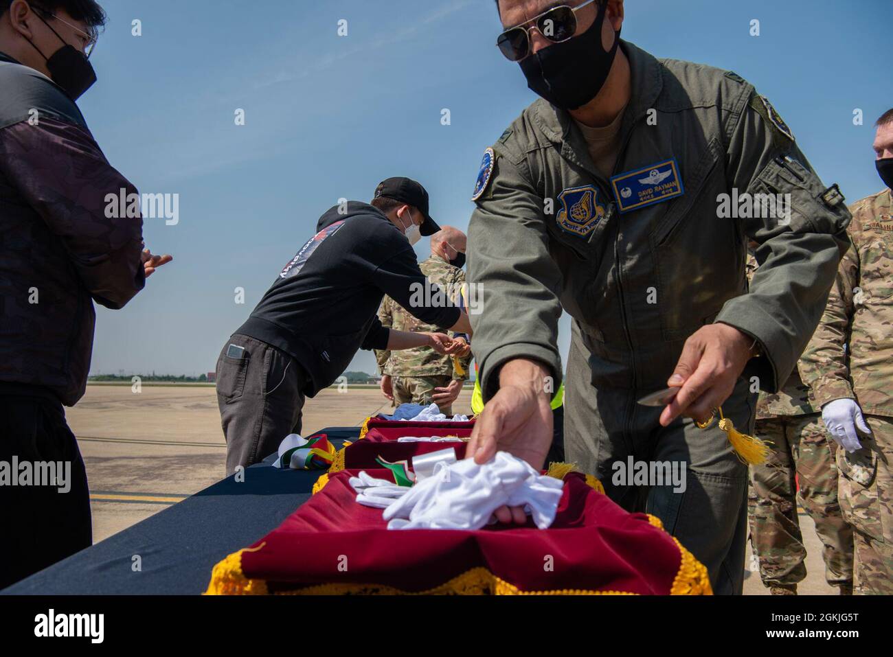 Col. Dave Rayman, Kommandant der 51. Operationsgruppe, nimmt ein Paar Handschuhe zur Erinnerung an eine Zeremonie des Bandschneidens auf der Hauptpiste der Osan Air Base, Republik Korea, 3. Mai 2021. Osan ist der Haupteintrittsort für alle Dienststellen in Korea, und seine Start- und Landebahn muss in der Lage sein, mehrere Flugzeuge zu handhaben. Stockfoto