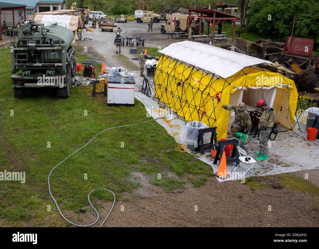 210503-N-PC620-0021 LAGER ATTERBURY, Ind. (3. Mai 2021) eine Ansicht von oben einer Massendekontaminationslinie während der Übung Guardian Response 21 (GR 21) im städtischen Trainingszentrum Muscatatuck, Indiana, 3. Mai 2021. GR 21 ist eine jährliche Übung zur Schulung und Bewertung des chemischen, biologischen, radiologischen und nuklearen (CBRN) Response Enterprise (CRE) des Verteidigungsministeriums. Nach Abschluss der kulminierenden Schulungsveranstaltung werden die von der CRE zugewiesenen Einheiten so schnell wie möglich eingesetzt, um die nichtstaatliche CBRN- oder Verteidigungsunterstützung für zivile Einsatzkräfte in den USA zu unterstützen. Stockfoto