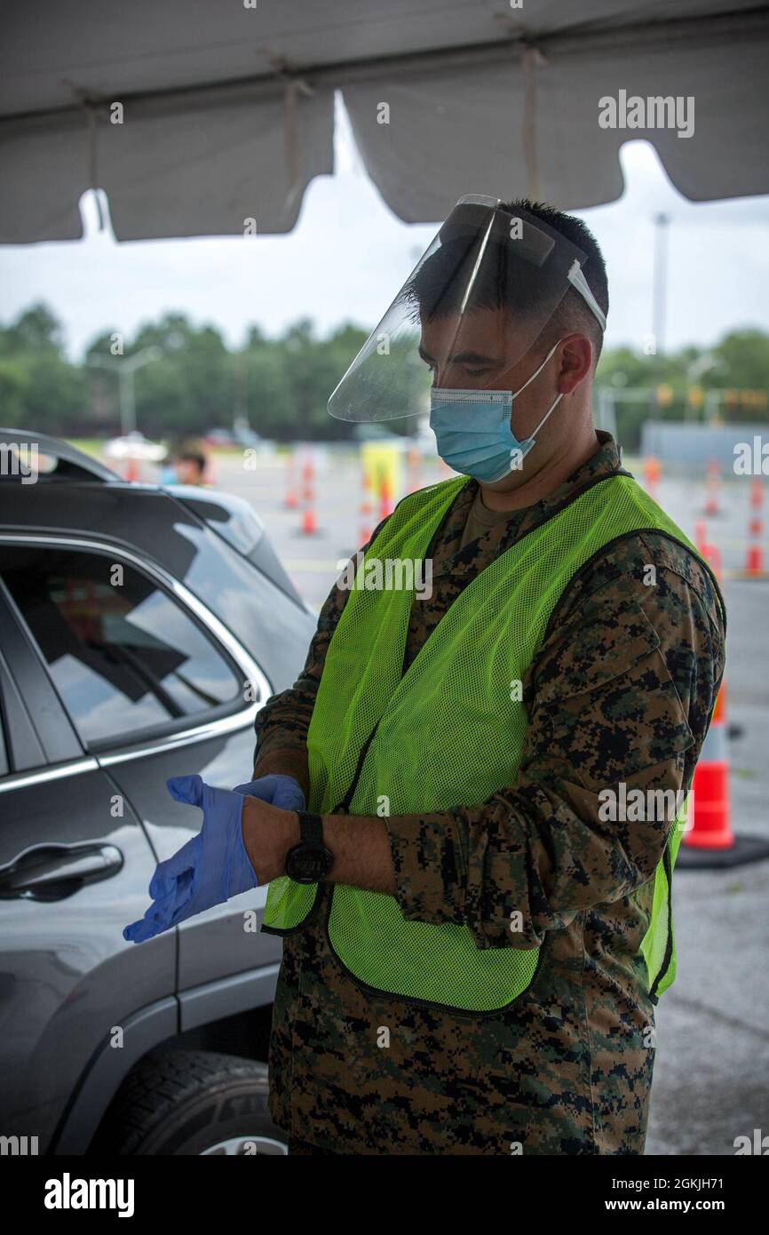 US Navy Petty Officer, 1. Klasse, Thomas Arnold, zugewiesen an das 1. Medizinische Bataillon, Charlie Company, Camp Pendleton California, Zieht seine Handschuhe an, um einen Impfstoff zu verabreichen, während ein Gemeindemitglied seinen Registrierungsprozess im Community Impfzentrum im Bon Carre Business Center in Baton Rouge Louisiana, 4. Mai 2021, einschließt. Arnold hält sich zusammen mit anderen Mitarbeitern des Verteidigungsministeriums strikt an alle Leitzentren zur Krankheitskontrolle. Das U.S. Northern Command setzt sich über die U.S. Army North weiterhin dafür ein, der Federa weiterhin flexible Unterstützung durch das Verteidigungsministerium zu bieten Stockfoto