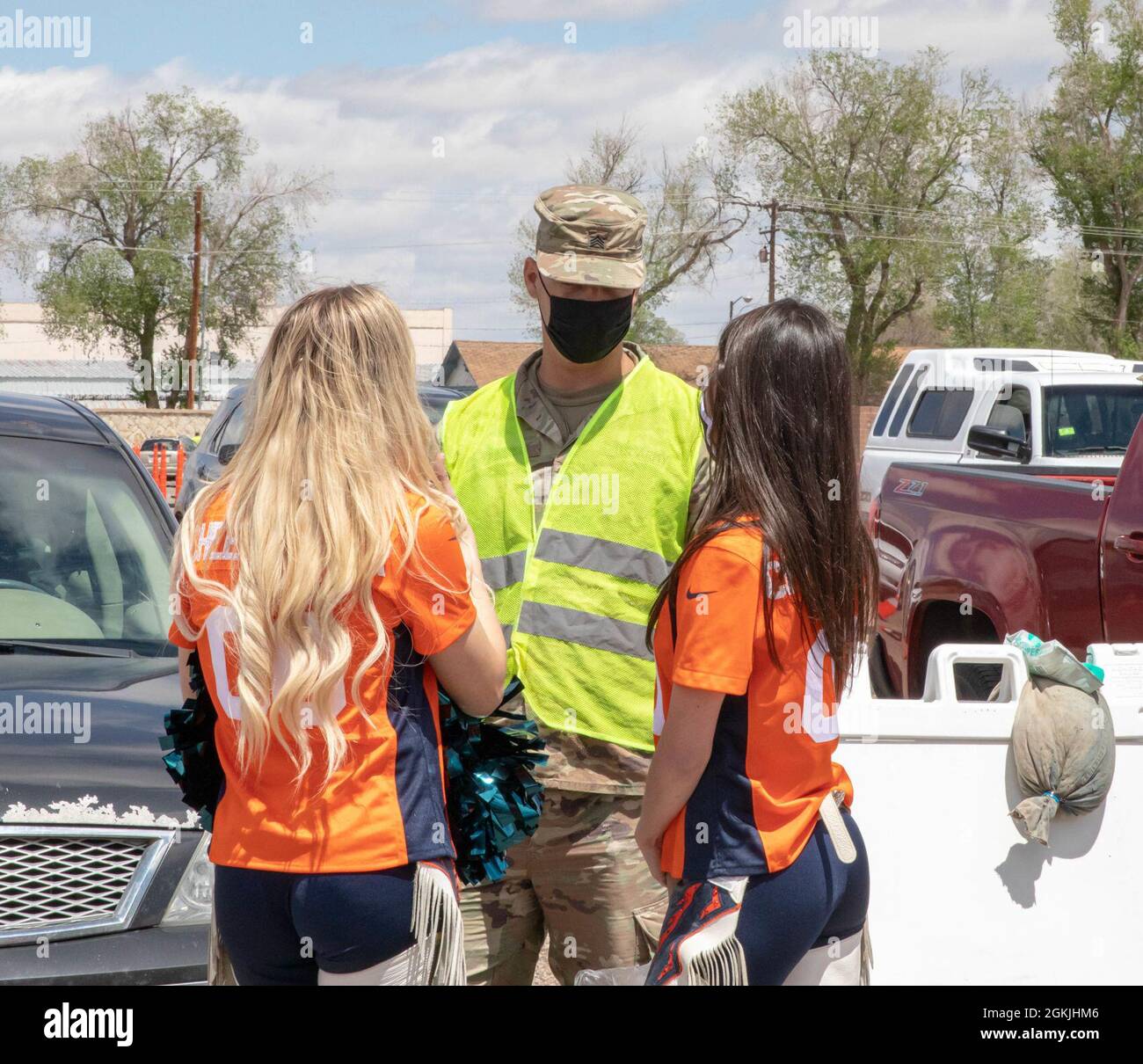 US Army Sgt. James Hines, ein Kavallerie-Scout, der der 3. Staffel, dem 61. Calvary Regiment, zugewiesen wurde, spricht mit Cheerleadern der Denver Broncos im Community Impfzentrum (CVC) auf dem Colorado State Fairgrounds in Pueblo, Colorado, 4. Mai 2021. Das Maskottchen der Denver Broncos und Cheerleader besuchten den Pueblo CVC, um Soldaten und Gemeindemitglieder zu unterstützen. Das U.S. Northern Command setzt sich über die U.S. Army North weiterhin dafür ein, die Federal Emergency Management Agency im Rahmen der Reaktion der gesamten Regierung auf COVID-19 weiterhin flexibel und flexibel zu unterstützen. Stockfoto