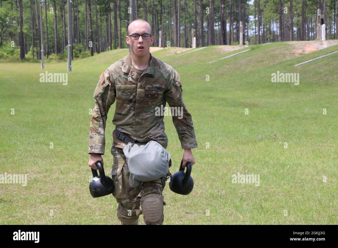 Spc. Gavin Curry, ein Soldat, der der 6. Staffel, dem 8. Kavallerieregiment, der 3. Infanterie-Division, zugewiesen wurde, sprintet mit 45 Pfund Kettle Glocken als Teil einer Streshooting-Übung im Small Arms Range Delta während des Soldier and Non Commissioned Officer of the Year Wettbewerbs der Division auf Fort Stewart, Georgia, 4. Mai 2021. Der Streßschuss testete die Fähigkeit der Soldaten, trotz körperlicher Belastung präzise zu feuern. Die Kandidaten müssen alle anderen Konkurrenten sowohl in körperlicher als auch geistiger Härte sowie in technischen und taktischen Kenntnissen und Fähigkeiten übertreffen, um durch das Korps, Majo, zu gehen Stockfoto