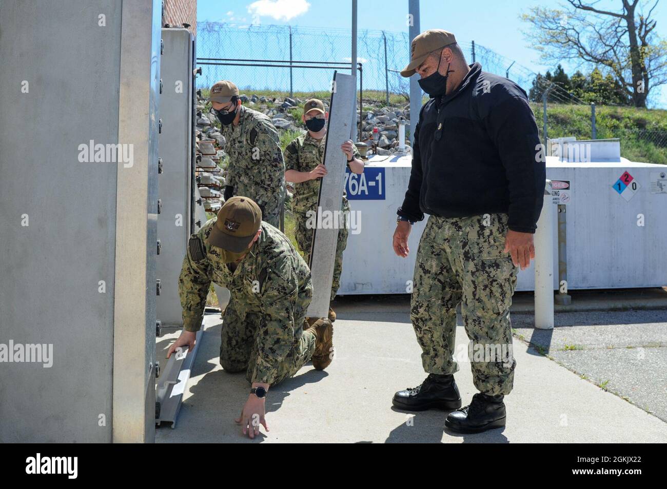 210507-N-EJ843-029 GROTON, Connecticut (7. Mai 2021)-Seeleute, die der Naval Submarine Support Facility (NSSF) Waffenabteilung an Bord des Naval Submarine Base New London zugewiesen wurden, haben im Rahmen der Hurrian Exercise/Citadel Gale 2021 (HURREX/CG 21) Hochwassertore errichtet, um eine Tür zu sichern. HURREX/CG 21 ist eine jährliche Übung, die vom U.S. Fleet Forces Command and Commander, Navy Installations Command, geleitet wird und die es der Navy ermöglicht, ihre Reaktionspläne und Einsatzfähigkeiten bei widrigen Wetterbedingungen zu überprüfen, auszuüben und zu validieren und die Fähigkeit aufrechtzuerhalten, Kräfte unter den härtesten Bedingungen einzusetzen. Stockfoto