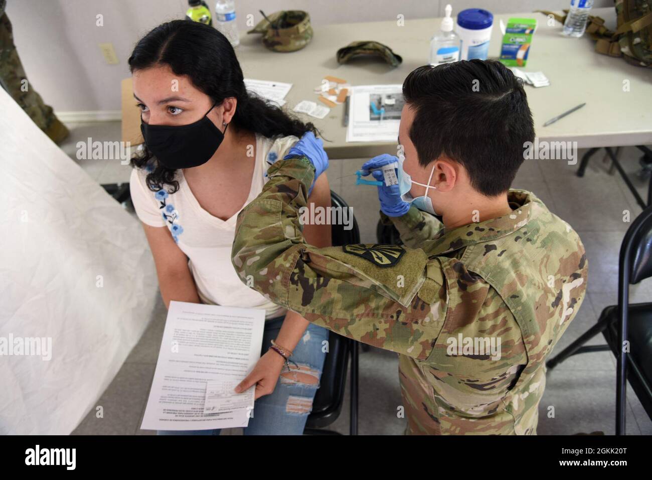 Pvt. Alyssa Hovland, 996. Area Support Medical Company, Kampfmediziner, verwaltet die COVID-19-Impfung an ein Stammesmitglied der Tohono O’odham Nation in Why, Arizona, 11. Mai 2021. Die Arizona National Guard hat sich mit dem Stamm zusammen gemacht, um Impfungen zu leisten und auch als Übersetzer für die überwiegend spanischsprachige Gemeinschaft zu fungieren. Stockfoto