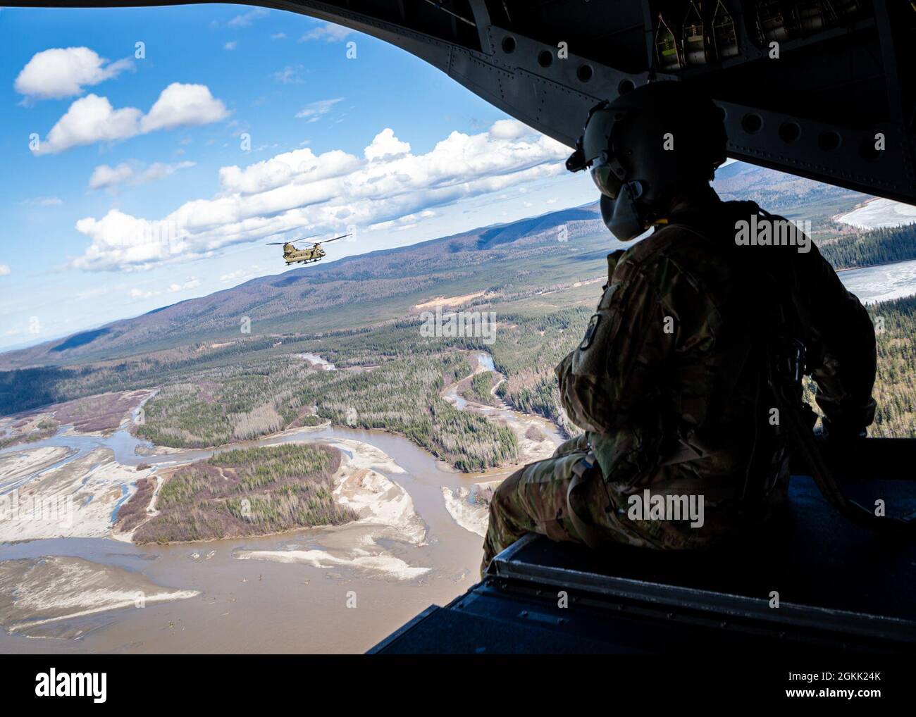 Ein Besatzungsleiter der US-Armee, der B Company, 1. Bataillon, 52. Luftfahrtregiment, zugewiesen wurde, sitzt auf der Rampe eines CH-47 Chinook, während er Alaska überfliegt, zur Unterstützung von Northern Edge 2021, 10. Mai 2021. Etwa 15,000 US-Dienstmitglieder nehmen an einer gemeinsamen Trainingsübung Teil, die vom 3. Bis 14. Mai 2021 von den US Pacific Air Forces auf und über dem Joint Pacific Alaska Range Complex, dem Golf von Alaska und dem Gebiet für temporäre maritime Aktivitäten veranstaltet wird. Stockfoto