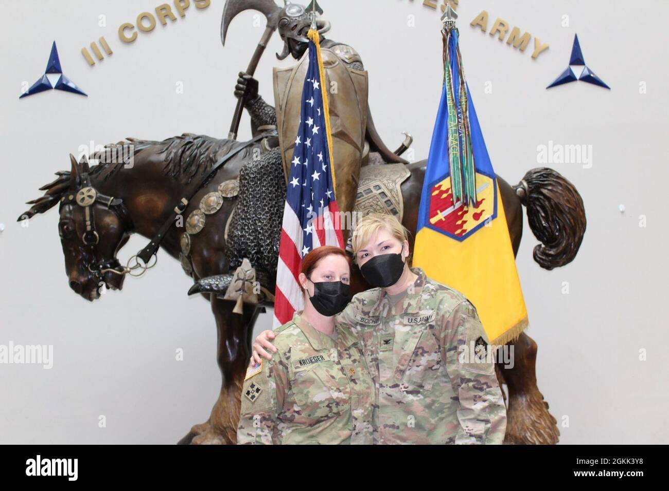 Col. W. Bochat (rechts), Kommandant der 48th Chemical Brigade, hält während der Beförderungszeremonie von Krueger im Atrium des III. Korps-Hauptquartiers für die Ärzteassistenten (Pas) von Capt. Krueger Karriere und Erfolge bereit. Stockfoto