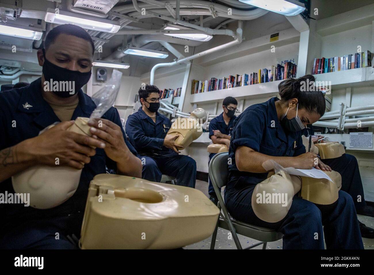 210512-N-XU073-1052 SÜDCHINESISCHES MEER (12. Mai 2021) – Seemanns führt erste-Hilfe-Training im Klassenzimmer an Bord des Arleigh Burke-Klasse Lenkraketenzerstörers USS Curtis Wilbur (DDG 54) durch. Curtis Wilbur wird der Task Force 71/Destroyer Squadron (DESRON) 15 zugewiesen, der größten Vorwärtsdresse der Marine und der wichtigsten Oberflächenkraft der US-Flotte der 7. Flotte. Stockfoto