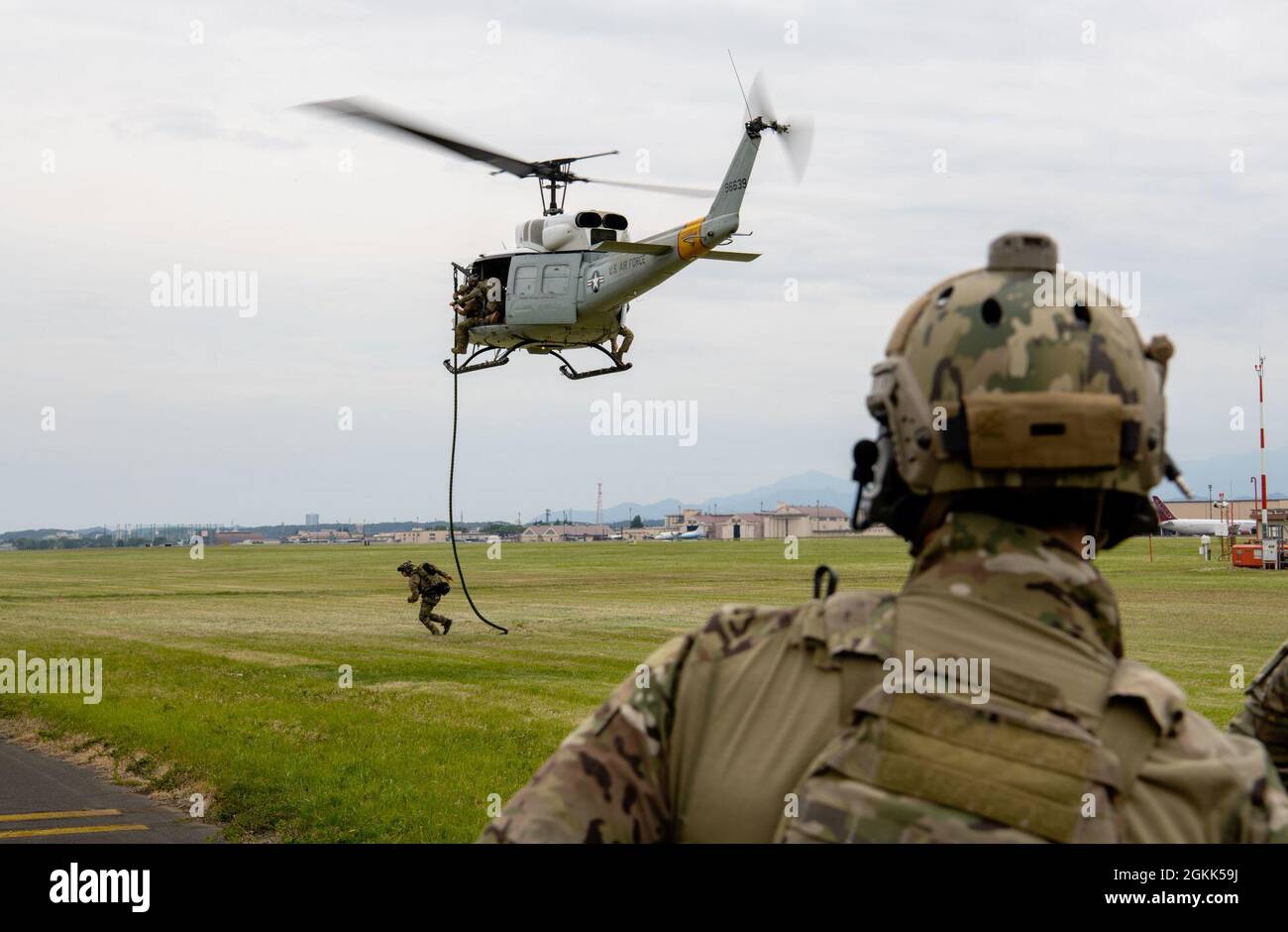 Ein 12. Special Tactics Airman läuft nach einem schnellen Rumping von einem UH-1N Iroquois Hubschrauber auf der Yokota Air Base, Japan, 2021. Mai zu einem Rallyepunkt. Zusammen mit dem schnellen Seil verwendet das 33. Spezialtaktiken-Geschwader mehrere Werkzeuge wie Seilleitern, Hebezeuge und Walddurchdringungssitze, um Personal in Flugzeuge zu heben, wenn Rettungseinsätze durchgeführt werden. Stockfoto