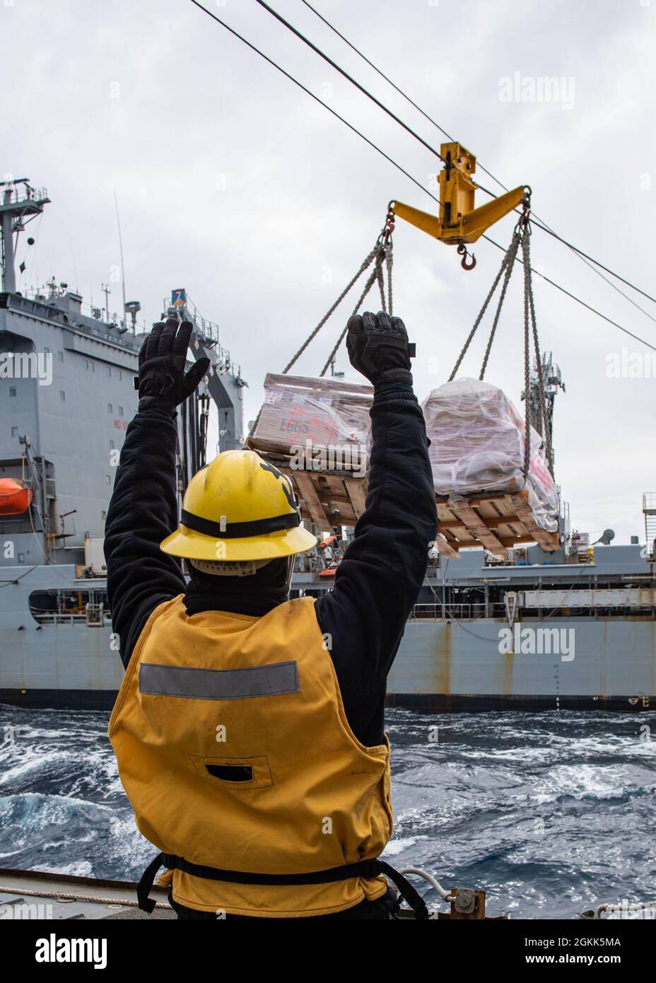 Mate Seaman Juan Silva der US-Marine aus Defiance, Ohio, signalisiert dem Schiffsnachfüller USNS Guadalupe (T-AO 200) der Henry J. Kaiser-Klasse, während er Fracht an Bord des Lenkrakenzerstörers USS Russell (DDG 59) der Arleigh Burke-Klasse empfängt, 12. Mai 2021, Während einer Auffüllung auf See zur Unterstützung von Flugoperationen über dem Joint Pacific Alaska Range Complex und dem Golf von Alaska während der Übung Northern Edge 2021 (NE21). Marine-, Luftwaffe- und Marineflugzeuge führten während des NE21 Flugmissionen durch und demonstrierten nahtlose, gemeinsame Kampffähigkeiten. Etwa 15,000 US-Servicemitglieder Stockfoto