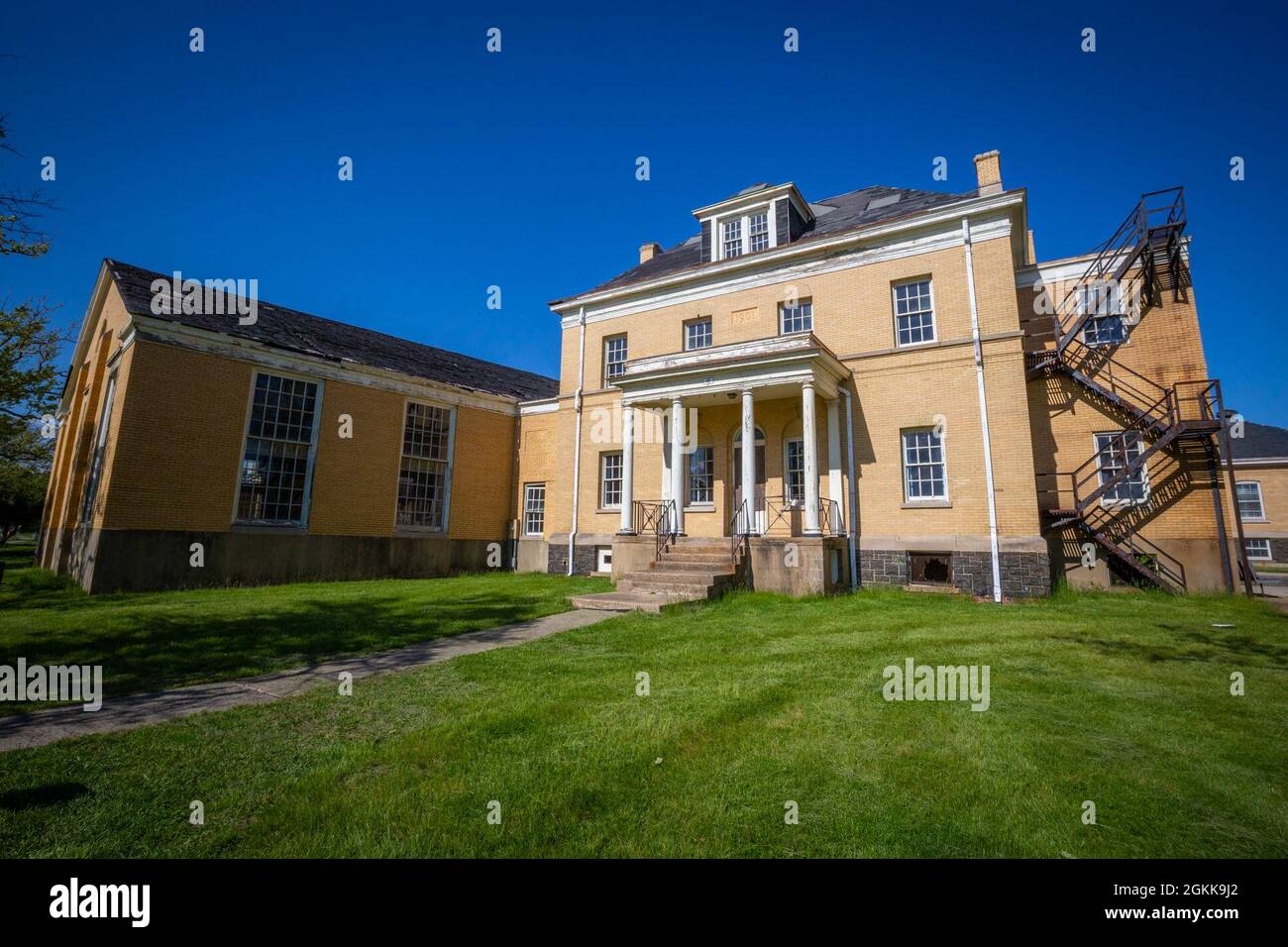 Gebäude der Young Men’s Christian Association in Fort Hancock, Gateway National Recreation Area in Sandy Hook, N.J., 13. Mai 2021. Die YMCA's, die mit privaten Beiträgen gebaut wurden, hatten ein Gymnasium, Spiel und Lesesäle. Im obersten Stockwerk gab es Gästezimmer für Familien, die die Soldaten besuchten. Der ursprüngliche Posten, der für die Garnison von 400 Soldaten, die die Batterien der Küstenverteidigungswaffe unterstützten, vorgesehen war, bestand aus 32 „Butterziegel“-Bauwerken der kolonialen Wiederbelebung, die um einen Paradeplatz herum errichtet wurden. Der Bau begann im Jahr 1898, wobei Männer in Baracken untergebracht waren, während sie noncomi heirateten Stockfoto