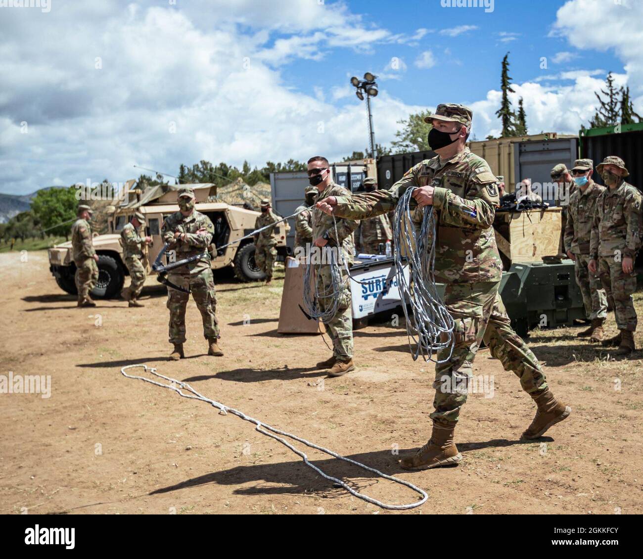 Der private First Class Stephen Goldin, ein Ingenieur des Alabama National Guard Bravo 753. Brigade Engineer Bataillon, und andere Mitglieder seiner Einheit üben das Werfen eines Greifhakens an einen Stolper-Draht. Das Ziel ist es, es während einer Übung im Rahmen von DEFENDER-Europe 21, in der Nähe von Xanthi, Griechenland, 16. Mai 2021, sicher aus der Ferne zu detonieren. Stockfoto