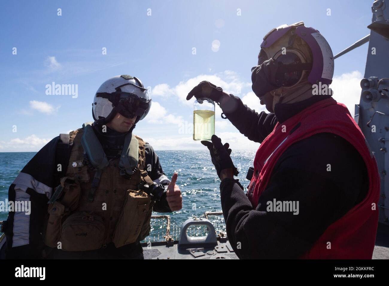 210517-N-CJ510-0174 ATLANTISCHER OZEAN (17. Mai 2021) Gas Turbine Systems Technician (Electrical) 3rd Class Joshua Ferdinand, rechts, zeigt eine Kraftstoffprobe an Naval Air Crewman (Hubschrauber) 2nd Class Morgan Larsh während des Flugbetriebs an Bord des Arleigh Burke-Klasse Lenkraketen-Zerstörers USS Roosevelt (DDG 80), 17. Mai 2021. At-Sea Demo/Formidable Shield, durchgeführt von Naval Streiks und Support Forces NATO im Auftrag der Sechsten US-Flotte, ist eine integrierte Luft- und Raketenabwehr (IAMD)-Übung, die die Interoperabilität der Alliierten mithilfe von NATO-Kommando- und Kontrollmeldestrukturen verbessert. Stockfoto