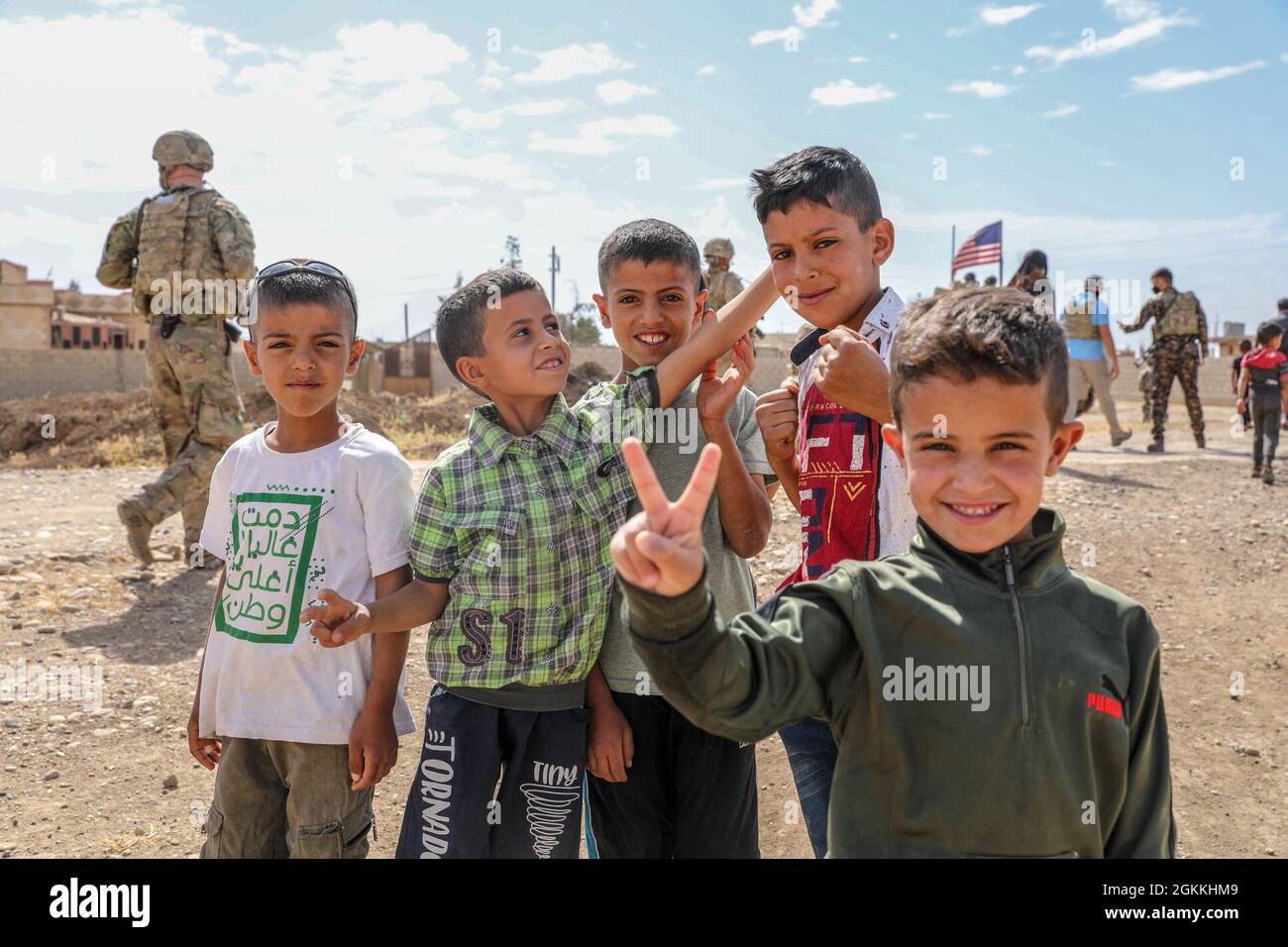 Soldaten der US-Armee halten während einer Routinepatrouille am 17. Mai in einem syrischen Dorf an, um über ein örtliches Ölauslaufen zu diskutieren. Während des Besuches hatten lokale Kinder freundschaftliche Interaktionen mit Soldaten, die die Verbundenheit und das Vertrauen zwischen der lokalen Gemeinde und dem US-Militär zeigen. Stockfoto