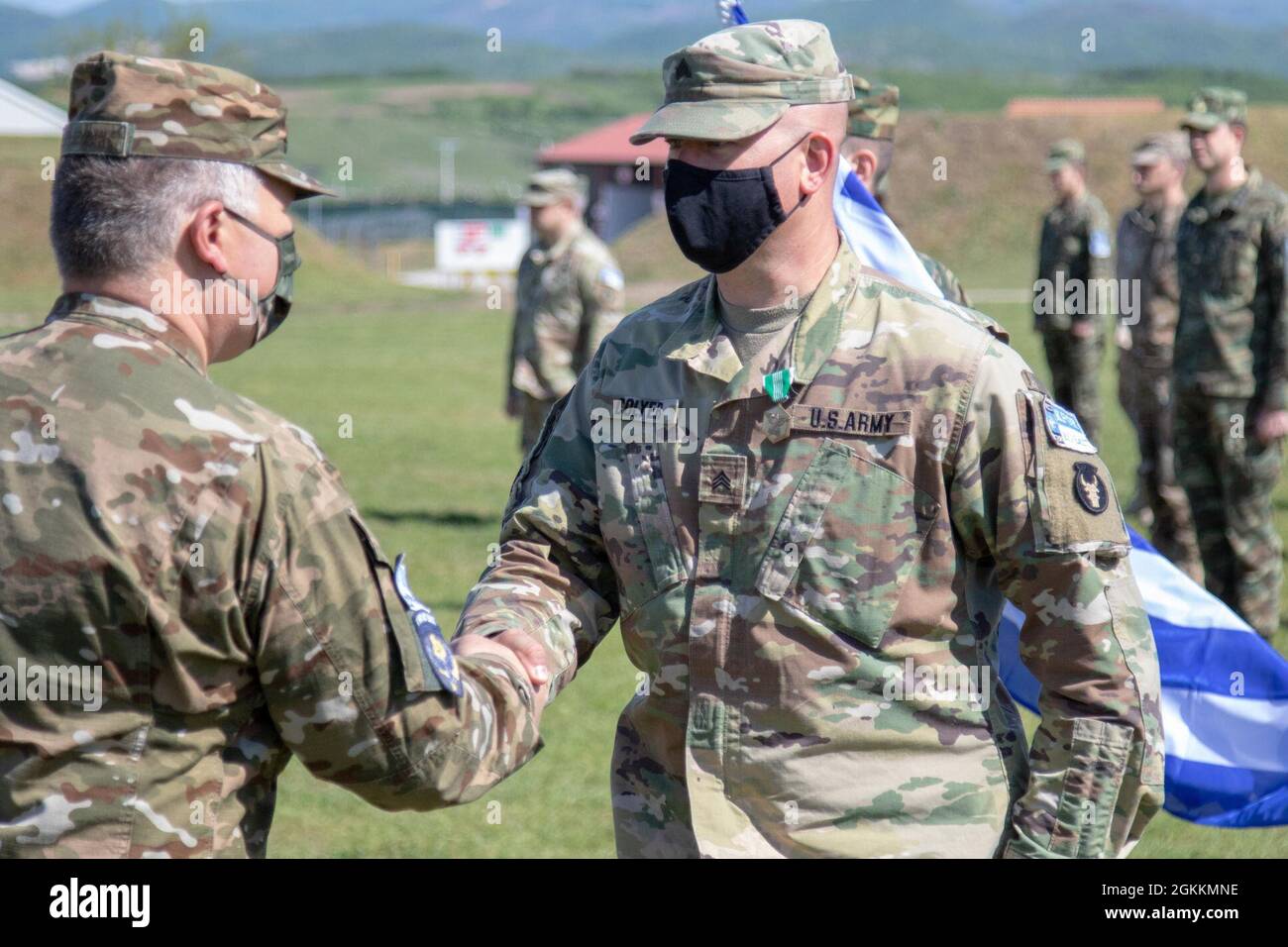 Sgt. Derrick Colyer, Teil des Liaison Monitoring Teams, schüttelt sich K21 die Hände mit Oberstleutnant Mihael Plevnik, nachdem er Colyer während einer Zeremonie im Camp Novo Selo am 18. Mai 2021 den Preis für das Ende der Tour verliehen hatte. Das Effects Bataillon ist eine Kombination aus multinationalen Streitkräften der NATO und alliierten Partnern des Regionalkommandos Ost, der Kosovo Force. Stockfoto