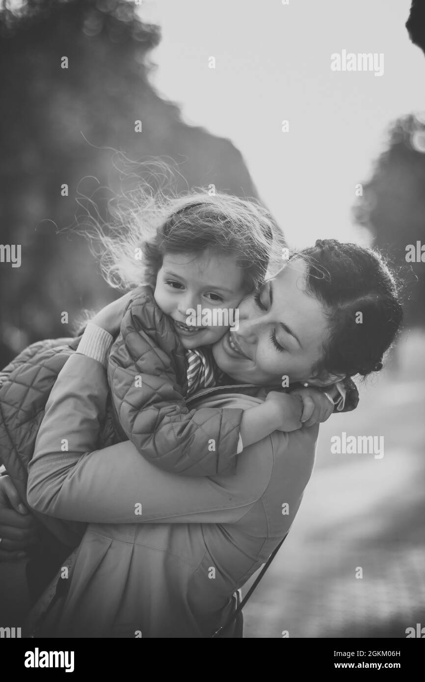 Schwarz-Weiß-Foto eines Mädchens, das ihre Mutter umarmt Stockfoto