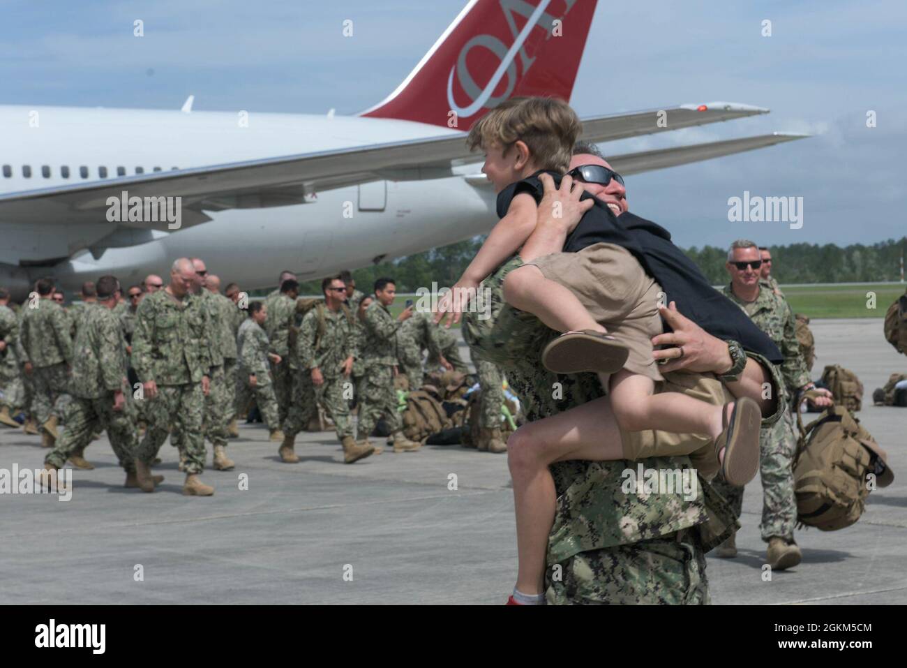 Mitglieder der Küstenwache Port Security Unit 308 treffen sich mit ihren Familienmitgliedern und Angehörigen am Stennis International Airport in Kiln, Missouri, nach einer neunmonatigen Entsendung in Guantanamo Bay, Kuba, am 22. Mai 2021. Die Hafensicherheitseinheiten werden mit den Kampfkommandos der Marine als Teil der maritimen Expeditionary Security Force eingesetzt, um ein geografisches Kampfkommando, einen Kommandanten der gemeinsamen Task Force oder einen Einsatzkommandanten der Küstenwache oder einen Einsatzkommandanten zu unterstützen. Stockfoto