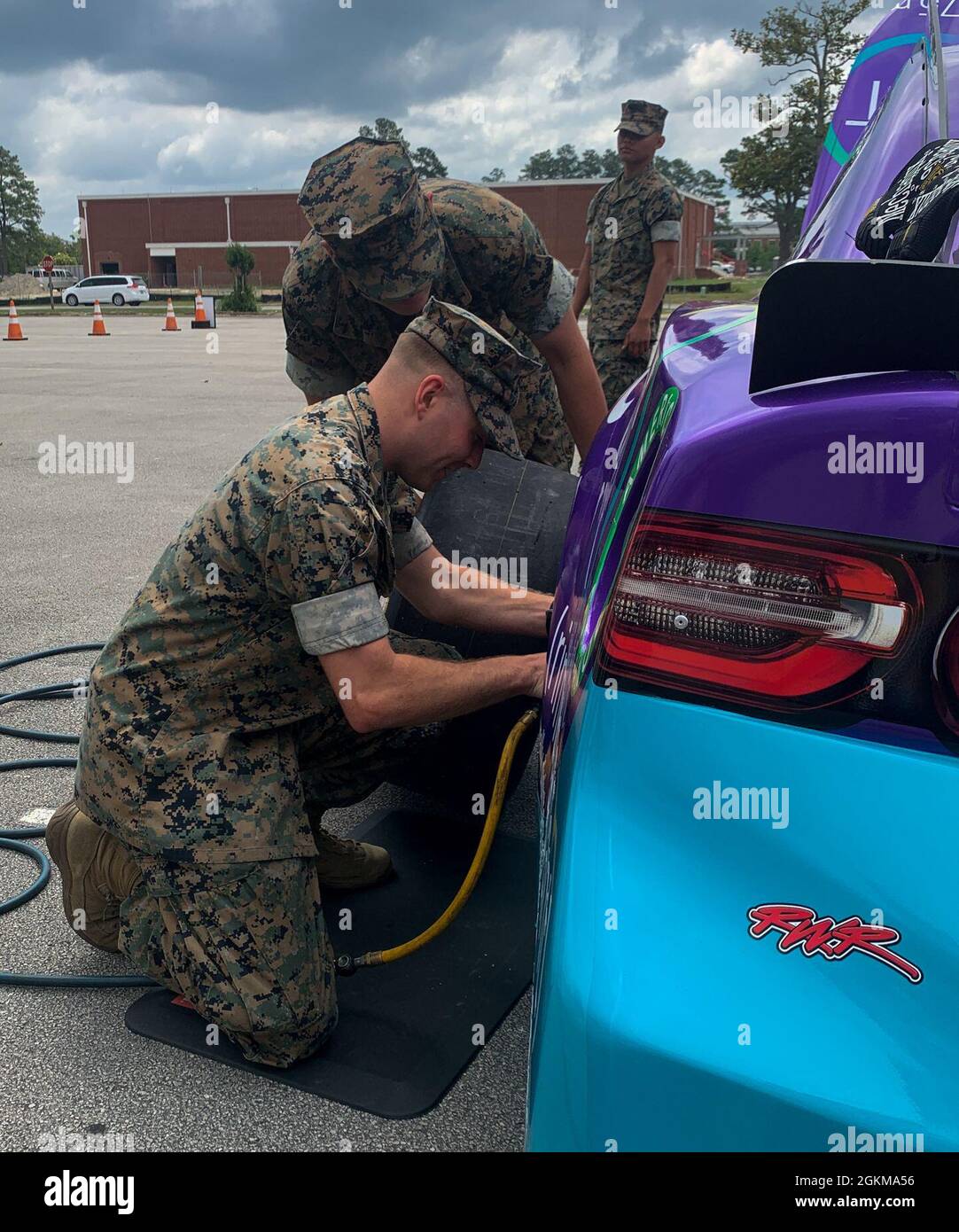 US-Marineinfanteristen, die derzeit an der Center for Naval Aviation Technical Training Unit (CNATTU) Cherry Point studieren, machen einen Scheinstopp auf dem Rennwagen der National Association for Stock Car Auto Racing (NASCAR) von Garrett Smithley, am Marine Corps Air Station (MCAS) Cherry Point, North Carolina, Mai 25, 2021. Smithley und sein Team waren bei MCAS Cherry Point zu Gast, um im Rahmen der „Military Salutes Campaign“ ein Treffen mit den Dienstmitgliedern, zivilen Mitarbeitern und ihren Familien zu veranstalten, um den Streitkräften zu danken. Das Vorhandensein von Werbung tut Stockfoto