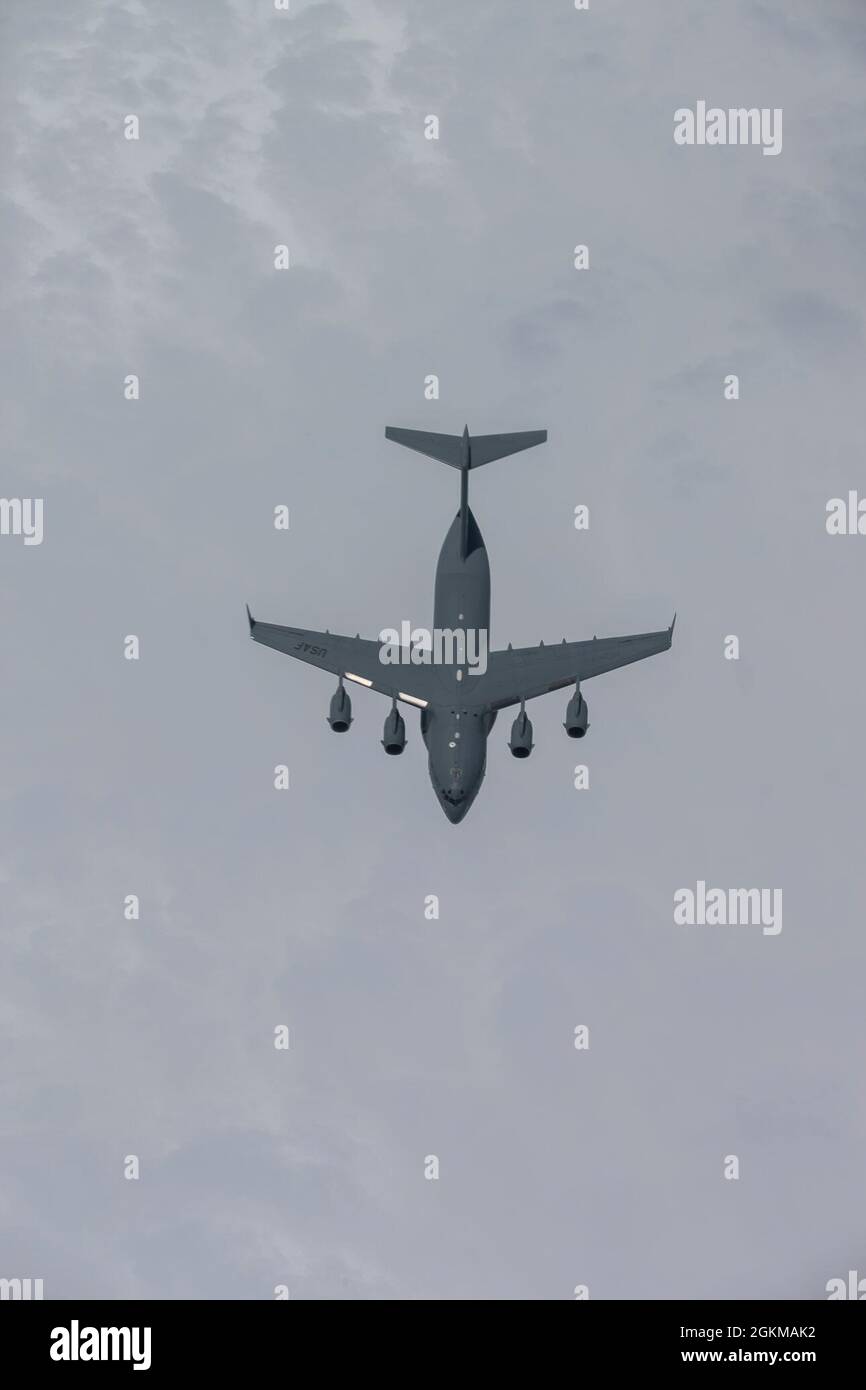 Ein C-17 Globemaster III der US-Luftwaffe mit dem 145. Luftlift-Flügel der North Carolina Air National Guard fliegt unter einem KC-135R-Stratotanker mit dem 141. Lufttankschwadron der New Jersey Air National Guard über dem Atlantik, 25. Mai 2021. Der Stratotanker KC-135R bietet Kernbetankungsfunktionen aus der Luft und verbessert die Fähigkeit der Luftwaffe, ihre primäre Mission der globalen Reichweite zu erfüllen. Stockfoto