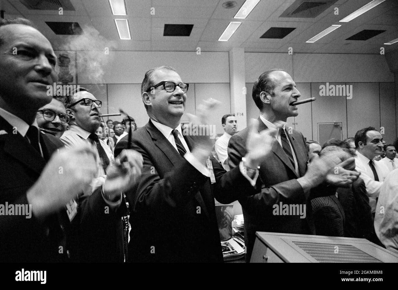 (17. April 1970) --- Mitarbeiter des NASA-Hauptquartiers (NASA-Hauptquartier), des bemannten Raumschiffszentrums (MSC) und Dr. Thomas Paine (Bildmitte) applaudieren dem erfolgreichen Abplatschen der Apollo 13-Mission, während Dr. George Low im MSC Mission Control Center (MCC) in Gebäude 30 eine Zigarre raucht (rechts). Apollo 13 Besatzungsmitglieder, Astronauten James A. Lovell Jr., Kommandant; John L. Swigert Jr., Kommandomodulpilot; und Fred W. Haise Jr., Mondmodulpilot, spritzten am 17. April 1970 um 12:07:44 Uhr (CST) im Südpazifik nieder. Stockfoto