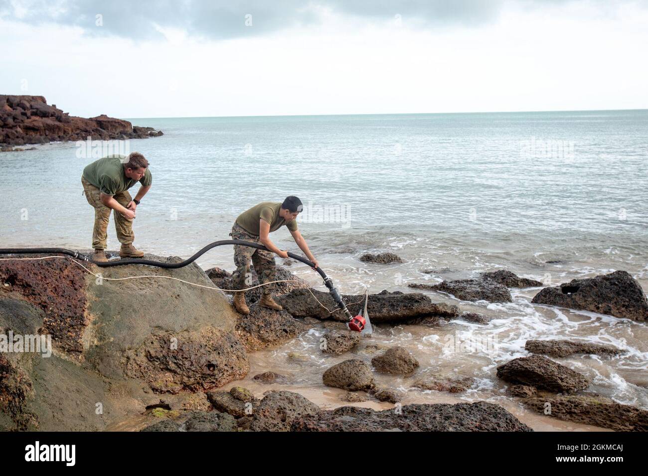 U.S. Marine Corps Lance CPL. Jerry GarciaVillegas, rechts, Wasserunterstützungstechniker beim Combat Logistics Bataillon 7, der Marine Rotational Force – Darwin und dem australischen Armeearbeiter Benjamin Flavell legen während der Übung Crocodile Response einen Anker für ein leichtes Wasserreinigungssystem bei Point Fawcett, NT, Australien, 25. Mai 2021. Mithilfe der LWPS des Marine Corps übten Marinesoldaten und Soldaten der australischen Armee ihre Fähigkeit aus, Wasser während einer simulierten Naturkatastrophe zu entsalzen. Übung Crocodile Response testete die Fähigkeit von MRF-D und der australischen Verteidigungskraft, eine Katastrophe zu schaffen Stockfoto