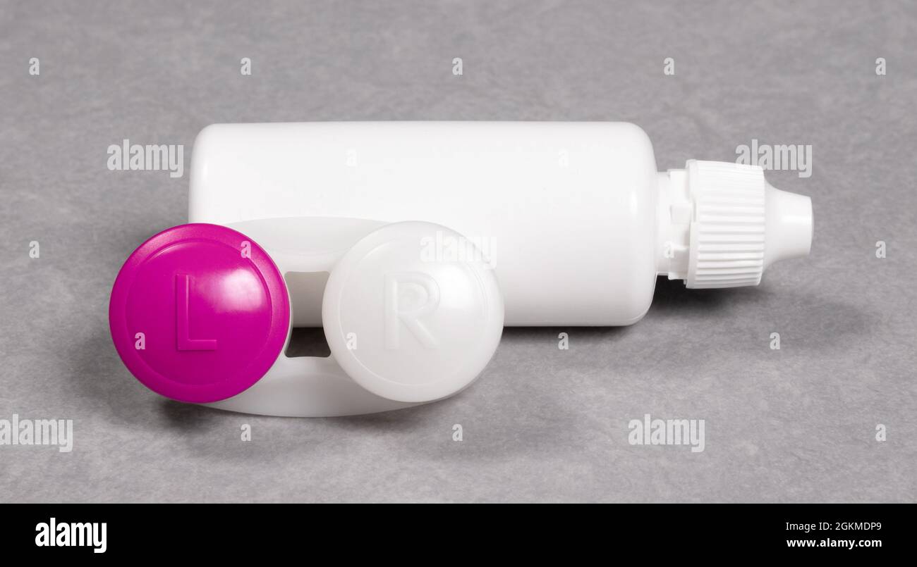 Rosa Kontaktlinsengehäuse und Flasche Lösung, isoliert auf grauem Hintergrund Stockfoto
