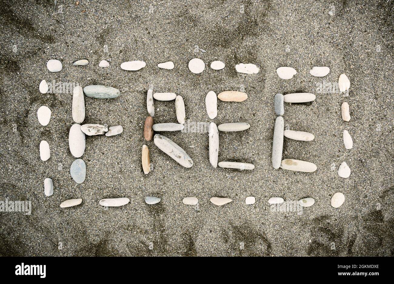 Inschrift von FREIEN Kieselsteinen am Sandstrand Stockfoto