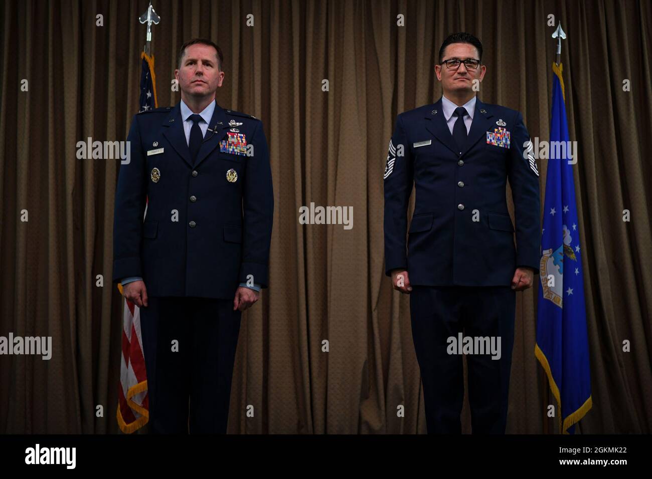 Col. Cameron Pringle, Kommandant des 319. Aufklärungsflügels, rechts, und Chief Master Sgt. Ryan Thuyns, Kommandochef des 319. Aufklärungsflügels, links, steht während der Ruhestandszeremonie von Thuyns auf dem Luftwaffenstützpunkt Grand Forks, N.D., 27. Mai 2021, zur Kenntnis. Thuyns ist seit 25 Jahren in der US-Luftwaffe tätig. Stockfoto