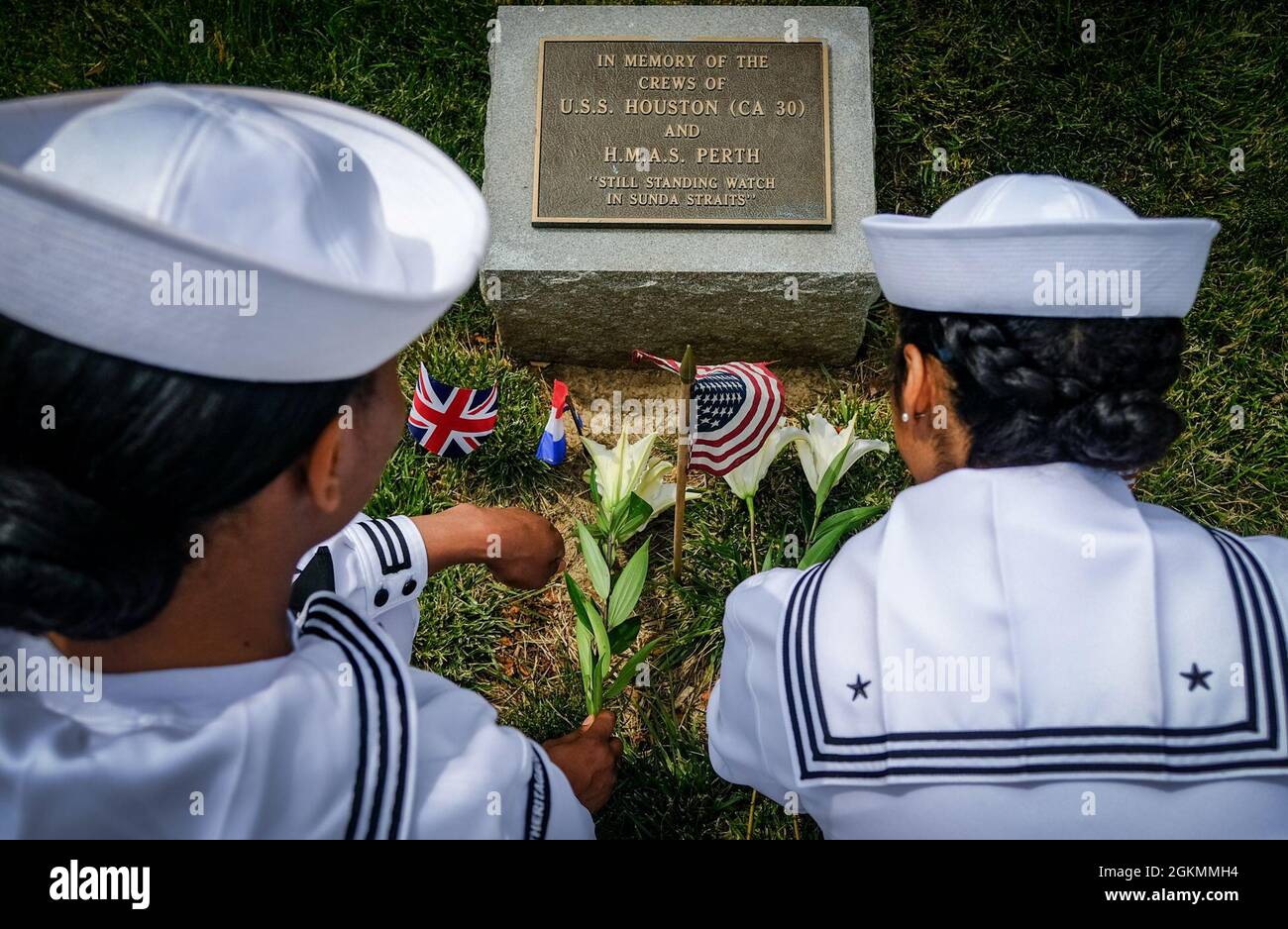 210528-N-CJ186-1016 ARLINGTON, VA. (28. Mai 2021) -- Yeoman (YN) 2nd Class LYNET Evans und YN2 Keeana Hodges, beide dem U.S. Naval History and Heritage Command (NHHC) zugeordnet, legen Blumen an den Gedenkstätten USS Houston (CA 30) und HMAS Perth (D 38) auf dem Arlington National Cemetery. In Verbindung mit dem Memorial Day Weekend nahmen sich NHHC und seine Partner einen Moment Zeit, um sich an das Erbe beider Schiffe zu erinnern und es zu ehren. Houston und Perth sind nach ihrer Niederlage im Kampf während der Schlacht an der Sundastraße im Zweiten Weltkrieg im Jahr 1942 noch immer auf See. Fast drei Viertel der 1,093 Besatzung von Houston starben auf See, und Stockfoto