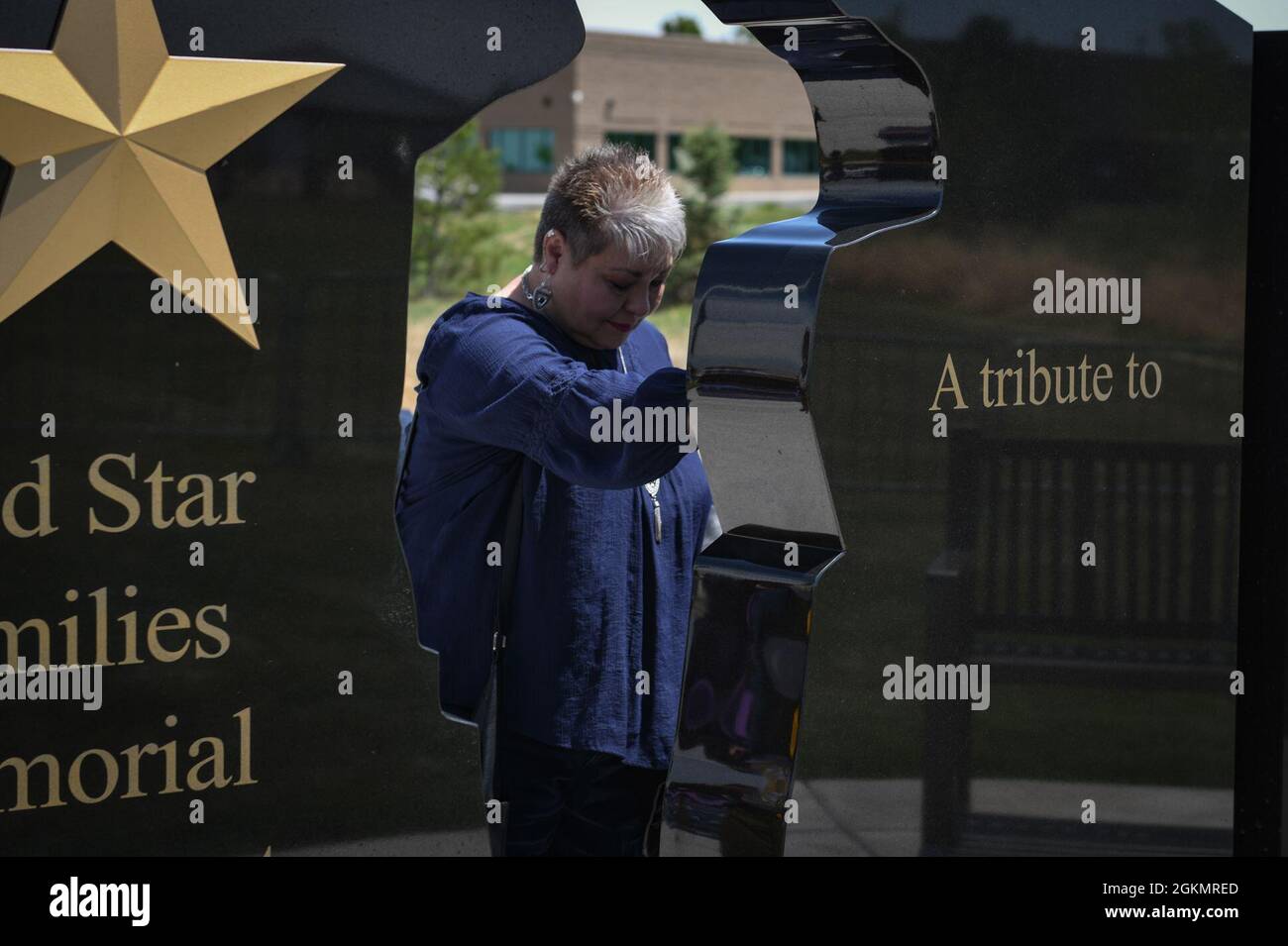 Eine Frau betet am Gold Star Families Memorial Monument am Colorado Freedom Memorial in Aurora, Colorado, 29. Mai 2021. Dieses Denkmal spiegelt die Gold Star Families und ihre gefallenen Helden der Gemeinde wider und zeigt gleichzeitig eine Silhouette eines geliebten Menschen, der das ultimative Opfer für die Freiheit zahlte. Stockfoto