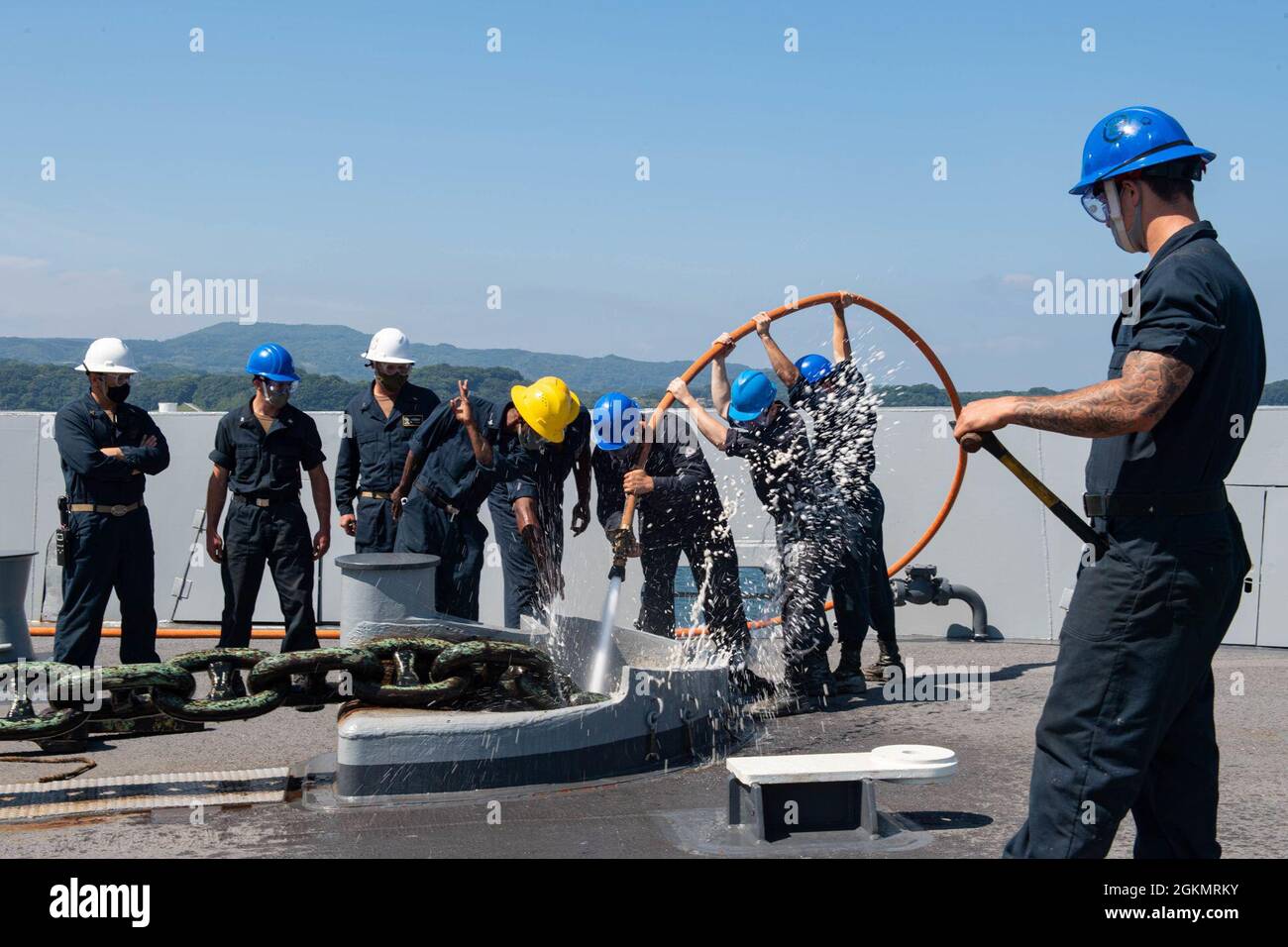 210529-N-XB010-1013 HAFEN SASEBO (29. Mai 2021) Seeleute an Bord der USS New Orleans (LPD 18) spülen die Ankerkette des Hafens mit einem Löschschlauch aus dem Meerwasser, während sie den Anker wiegen. New Orleans, Teil der America Amphibious Ready Group, arbeitet zusammen mit der 31. Marine Expeditionary Unit im Verantwortungsbereich der 7. US-Flotte, um die Interoperabilität mit Verbündeten und Partnern zu verbessern und als einsatzbereite Einsatztruppe zur Verteidigung von Frieden und Stabilität in der Indo-Pazifik-Region zu dienen. Stockfoto